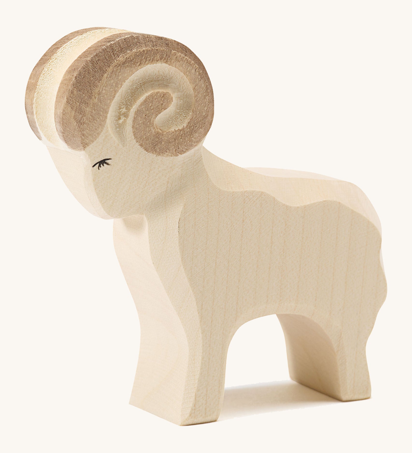 A white wooden Ostheimer standing ram figure on a cream background.