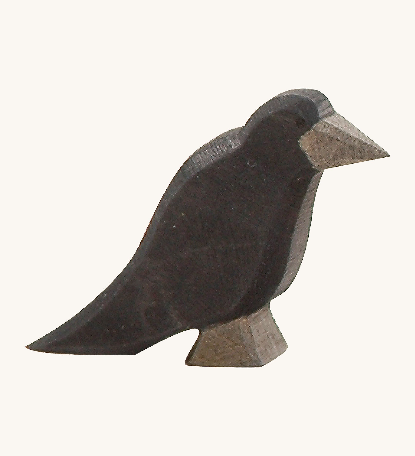 A wooden Ostheimer raven figure on a cream background