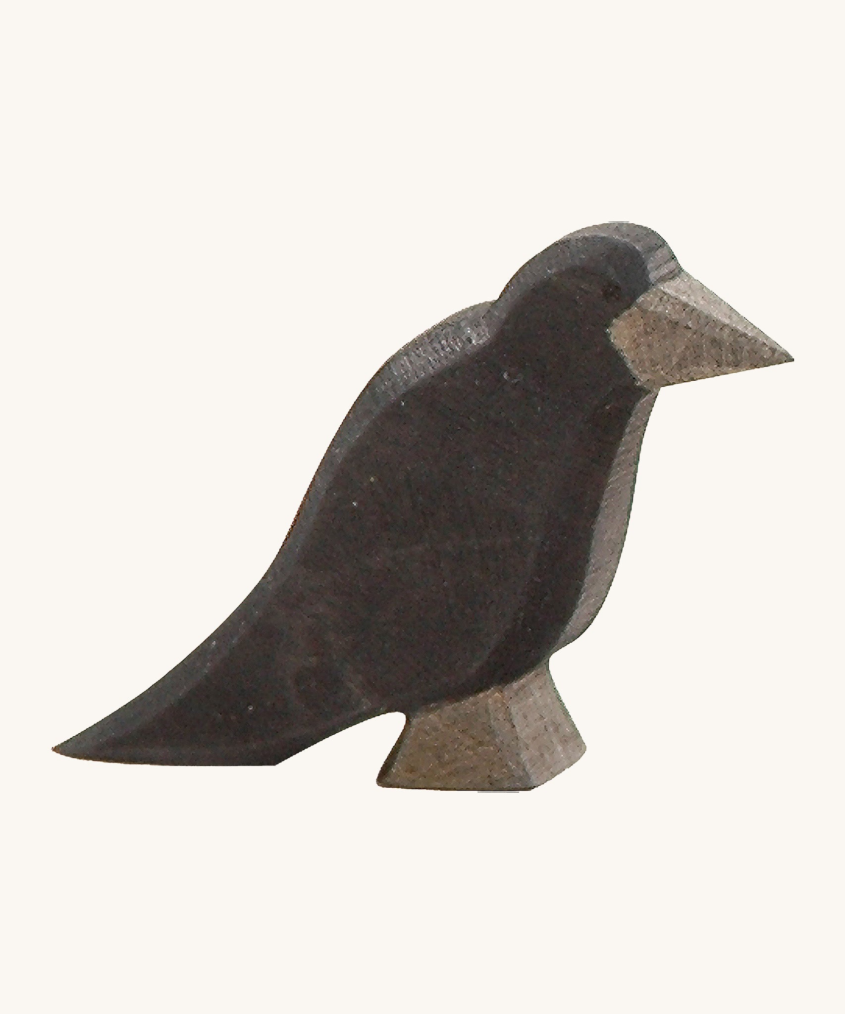 A wooden Ostheimer raven figure on a cream background