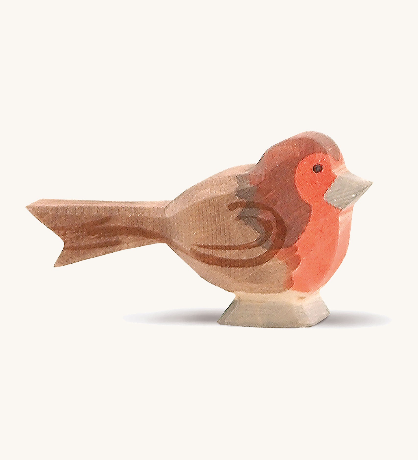 A wooden red breast Ostheimer bird figure on a cream background.