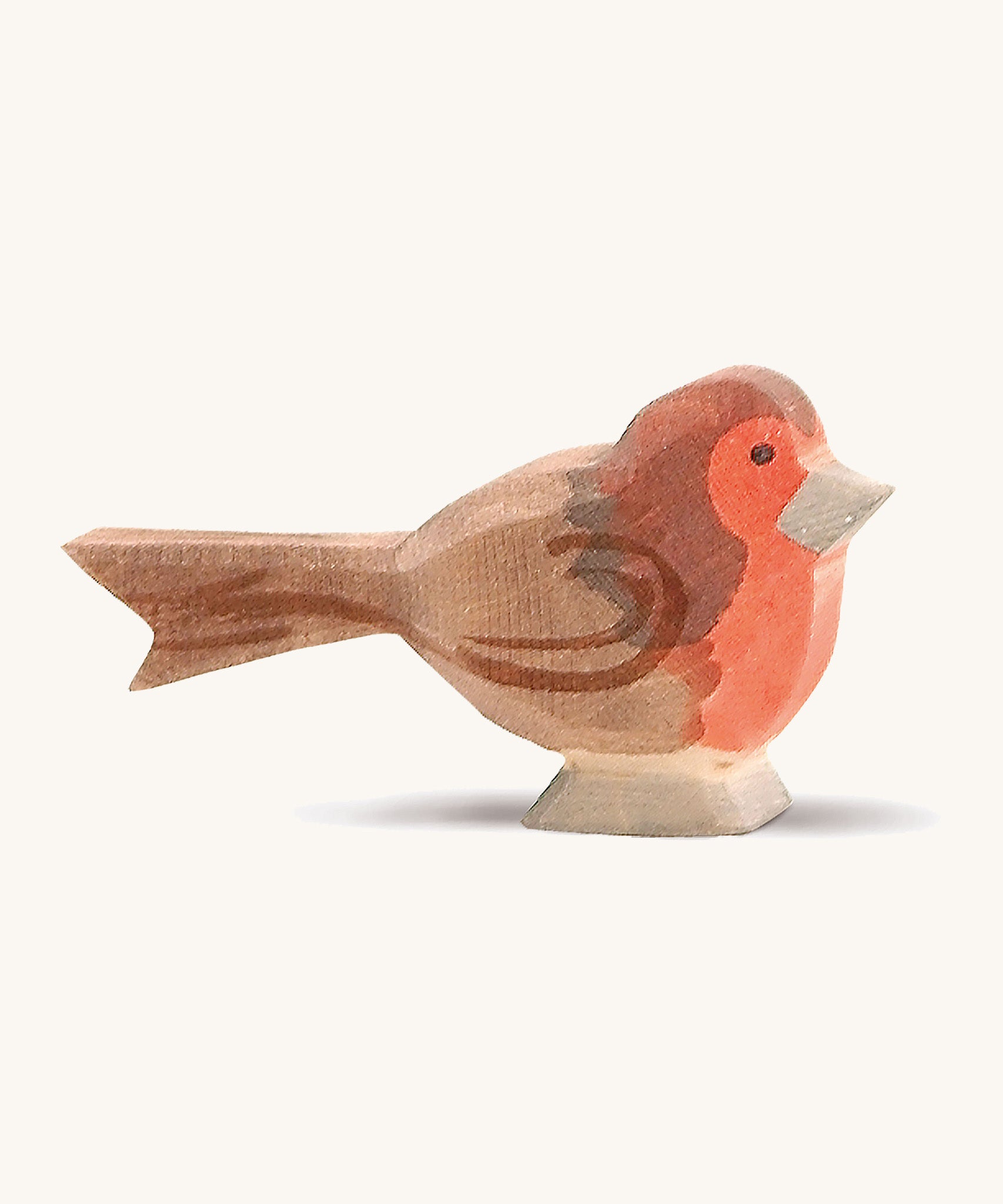 A wooden red breast Ostheimer bird figure on a cream background.