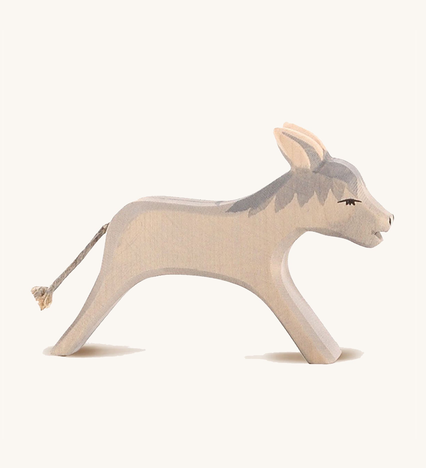 Ostheimer Running Donkey Wooden Figure, with a grey mane and cord tail. On a cream background