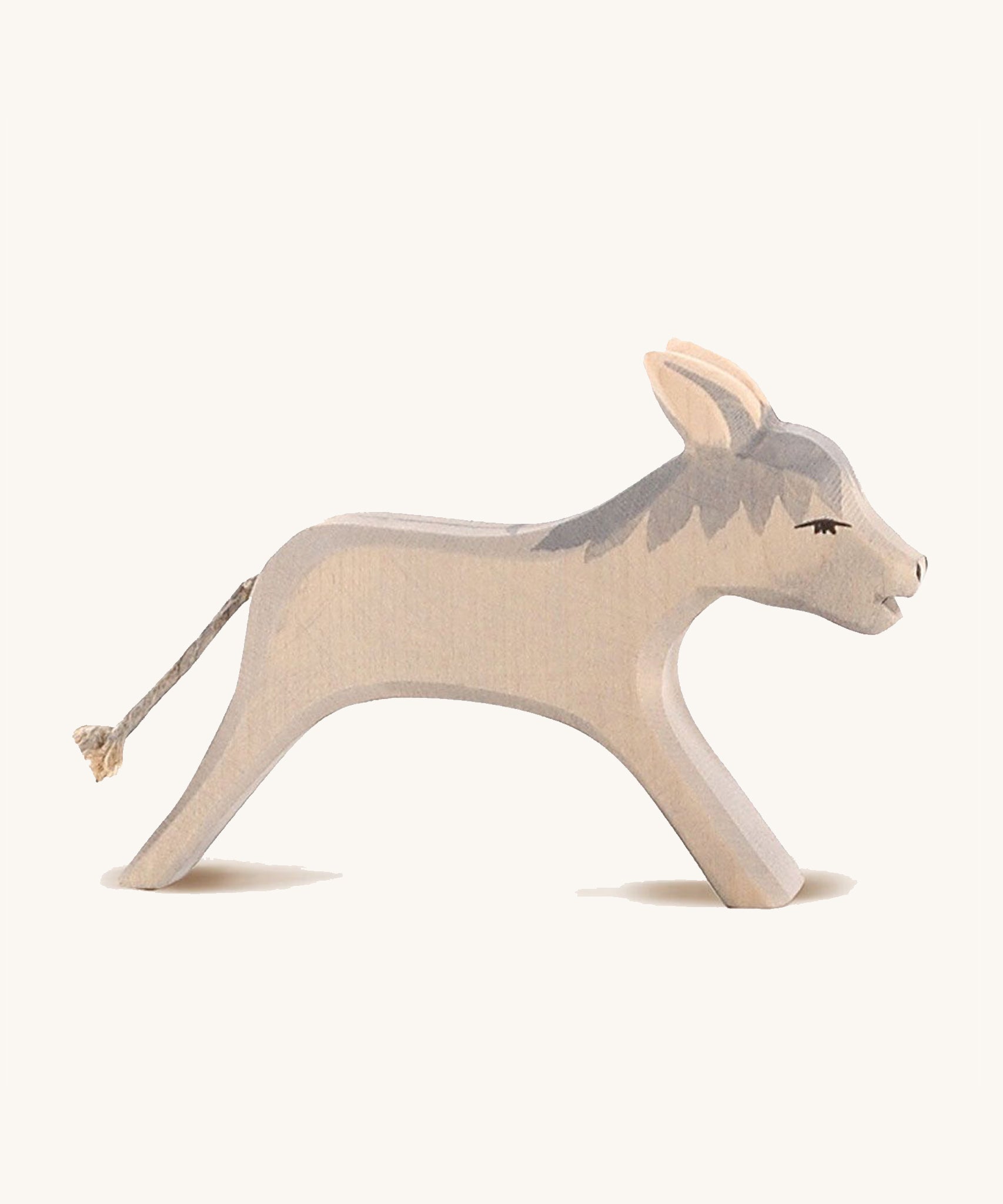 Ostheimer Running Donkey Wooden Figure, with a grey mane and cord tail. On a cream background