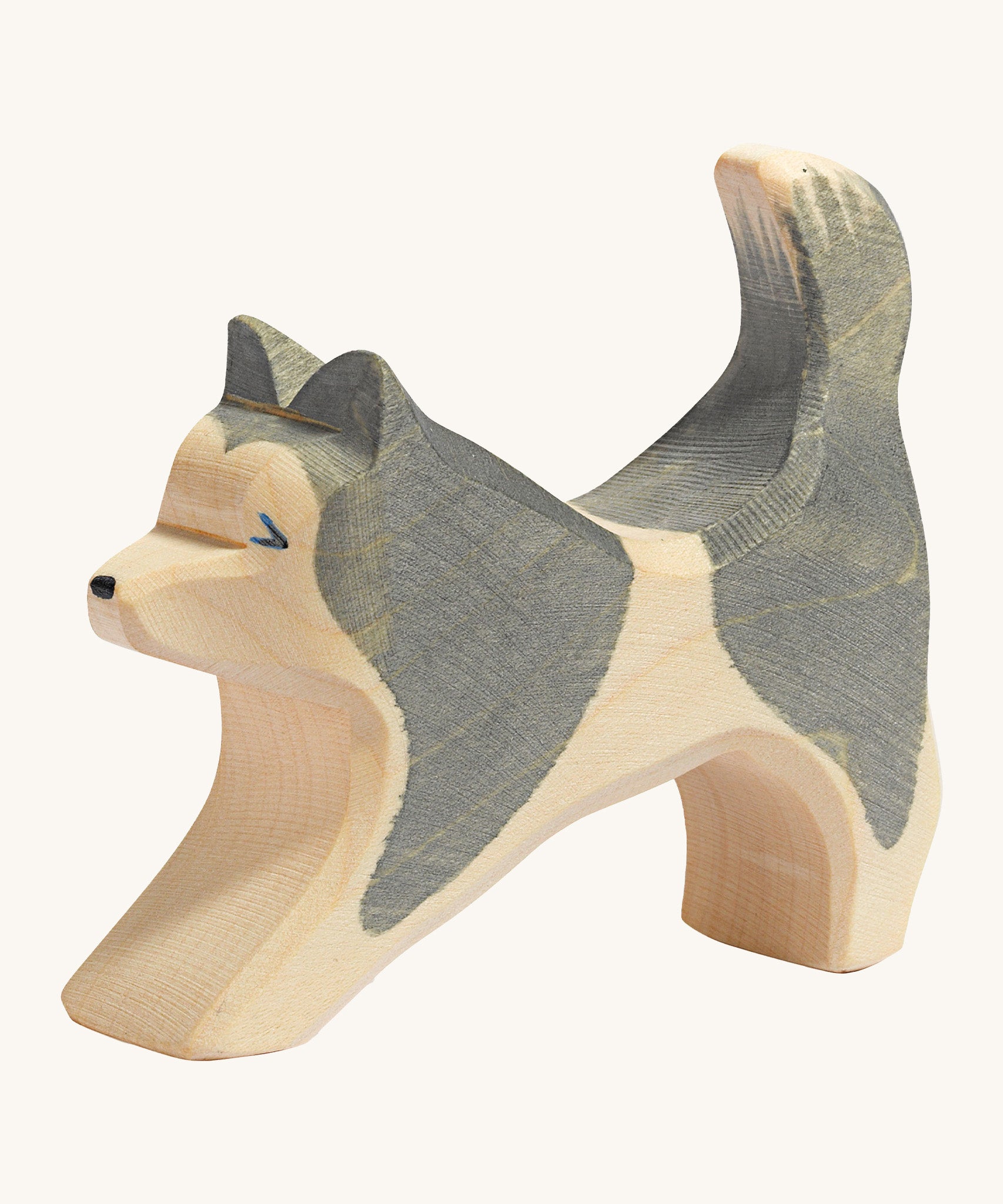 A grey and natural wooden Ostheimer running sled dog figure on a cream background.