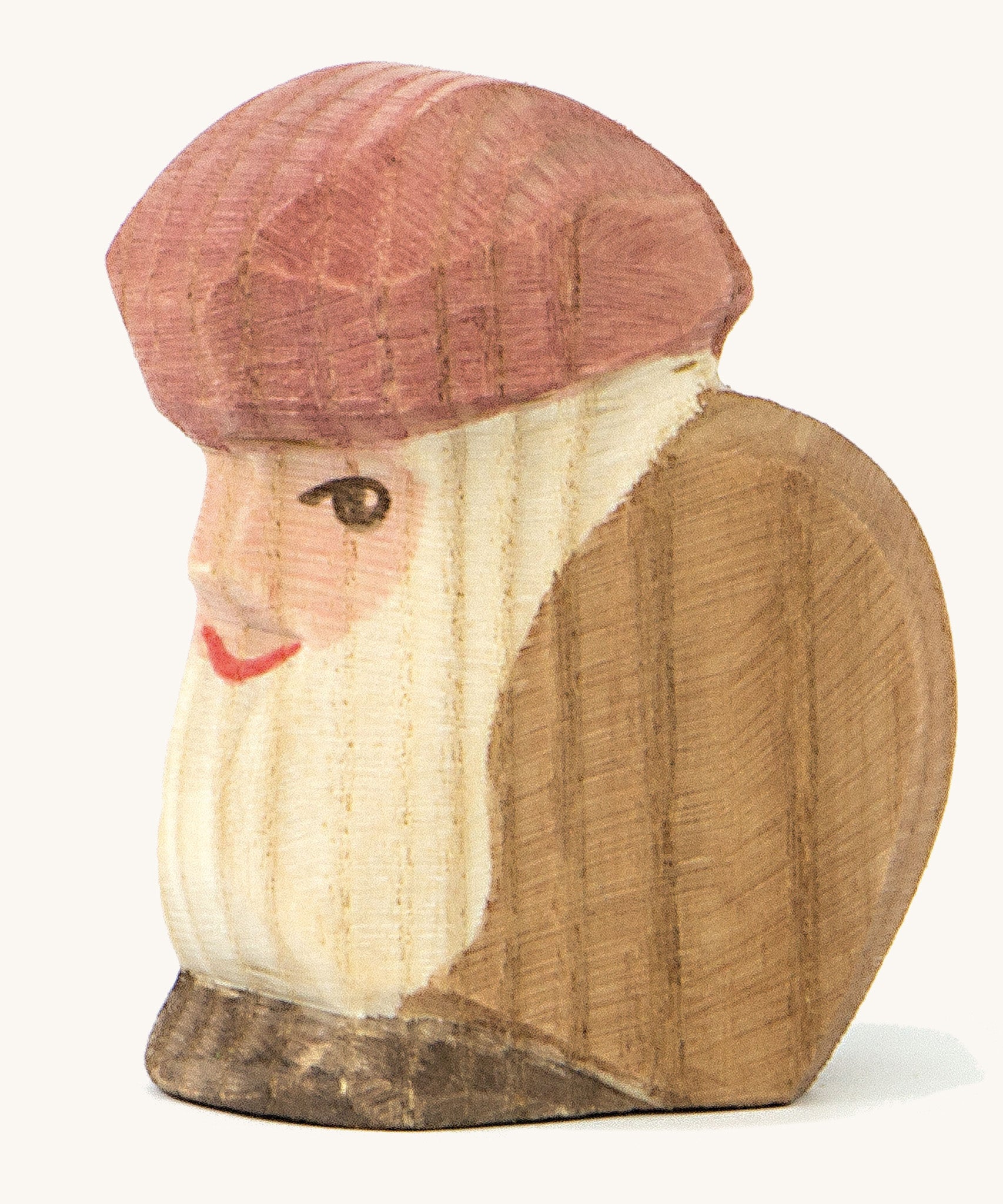 A wooden sitting dwarf wearing a brown top and a purple hat on a cream background.