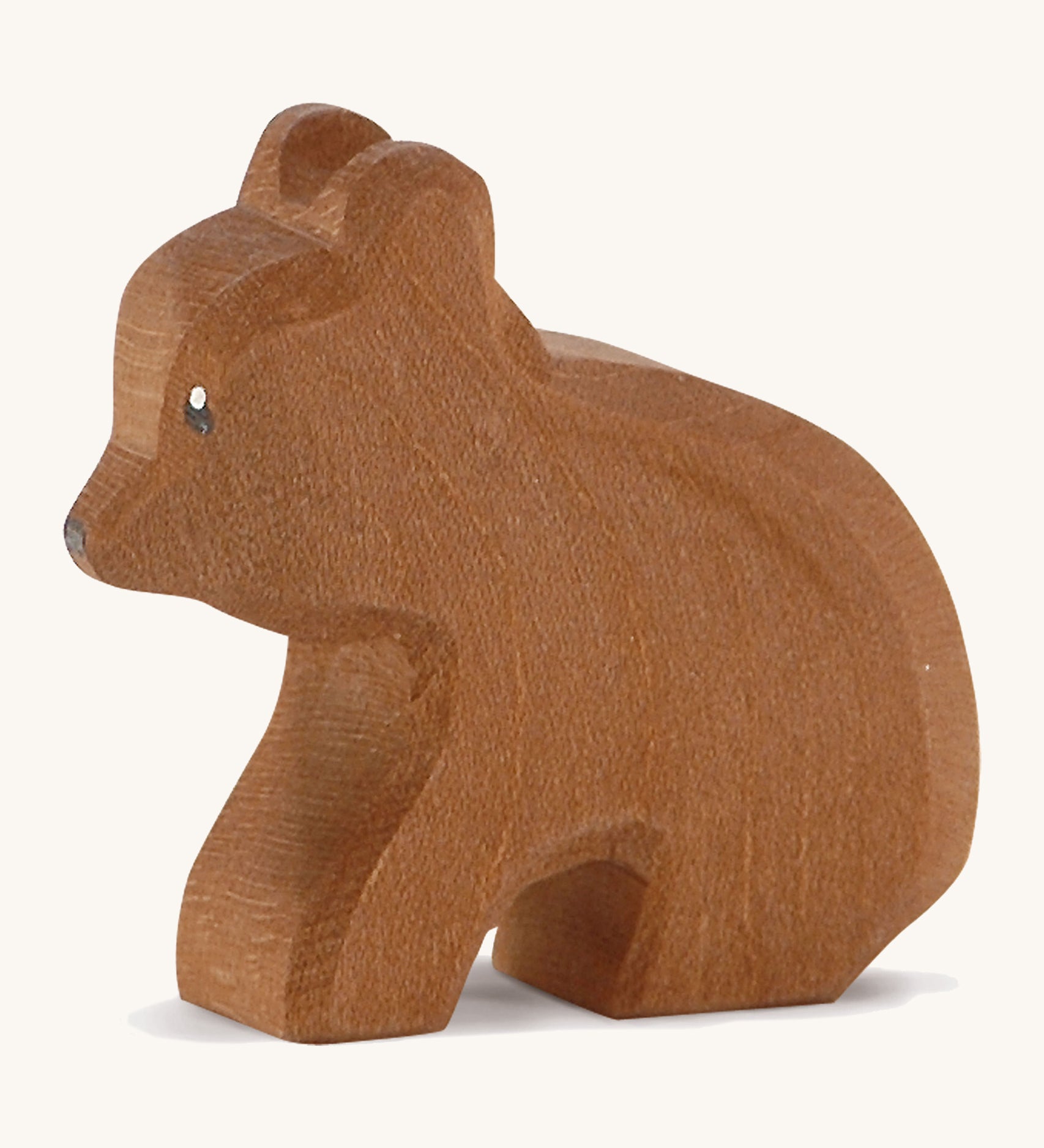 A Ostheimer wooden small brown sitting bear on a cream background.