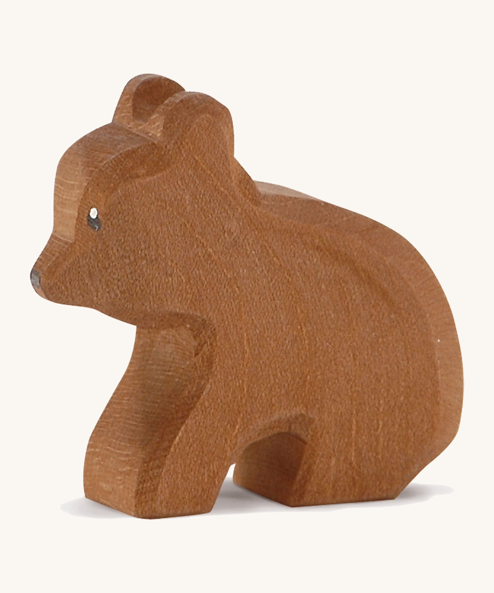 A Ostheimer wooden small brown sitting bear on a cream background.