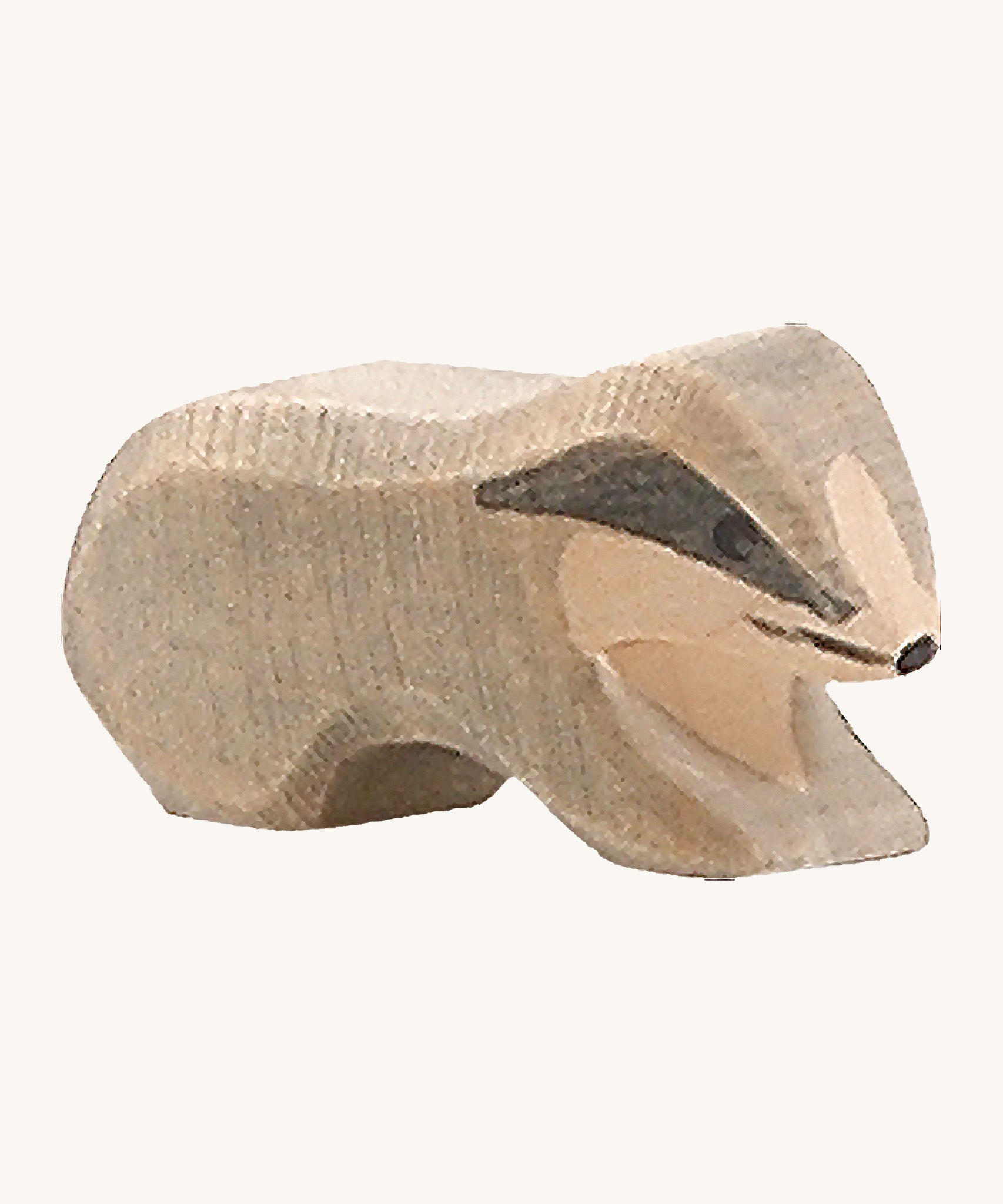 A small wooden Ostheimer badger figure on a cream background.