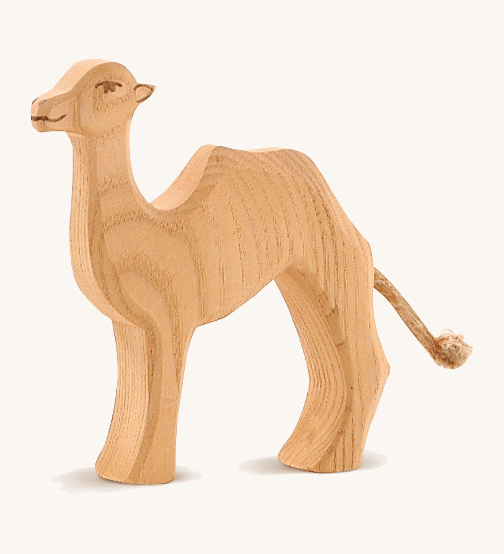 A small wooden Ostheimer camel on a cream background.