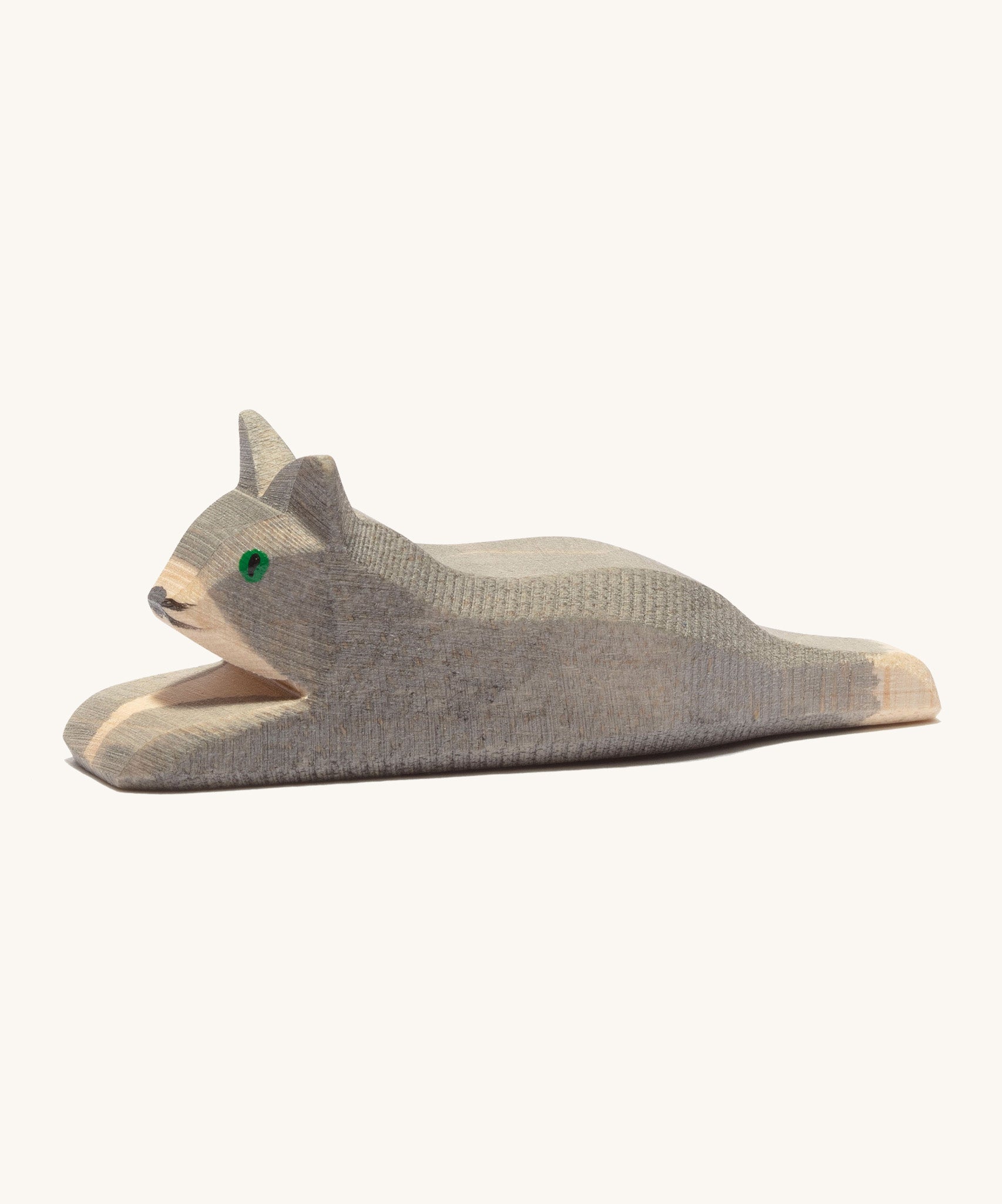 A grey wooden resting Ostheimer cat figure on a cream background.