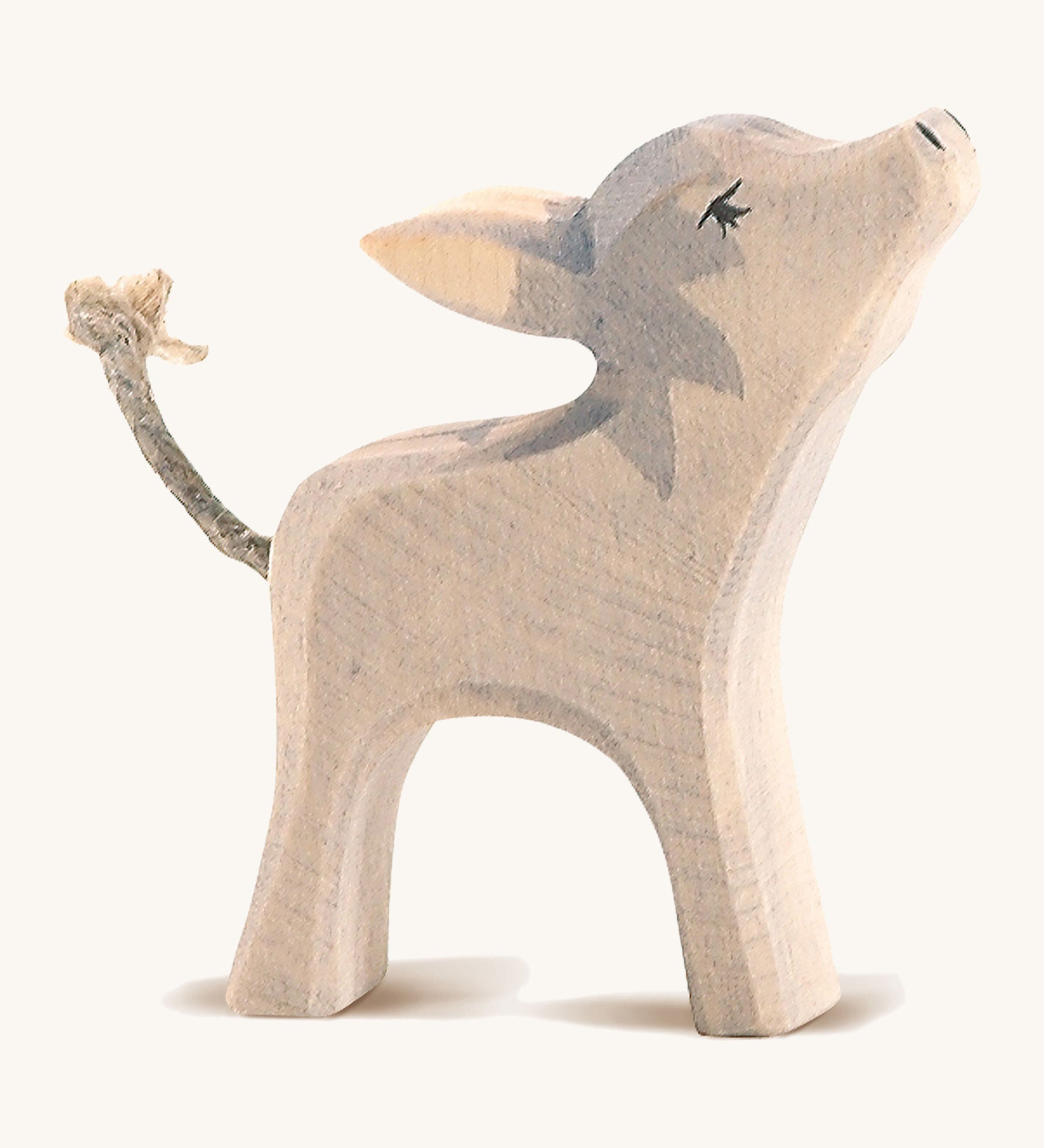 A small grey wooden Ostheimer donkey with its head held high on a cream background.