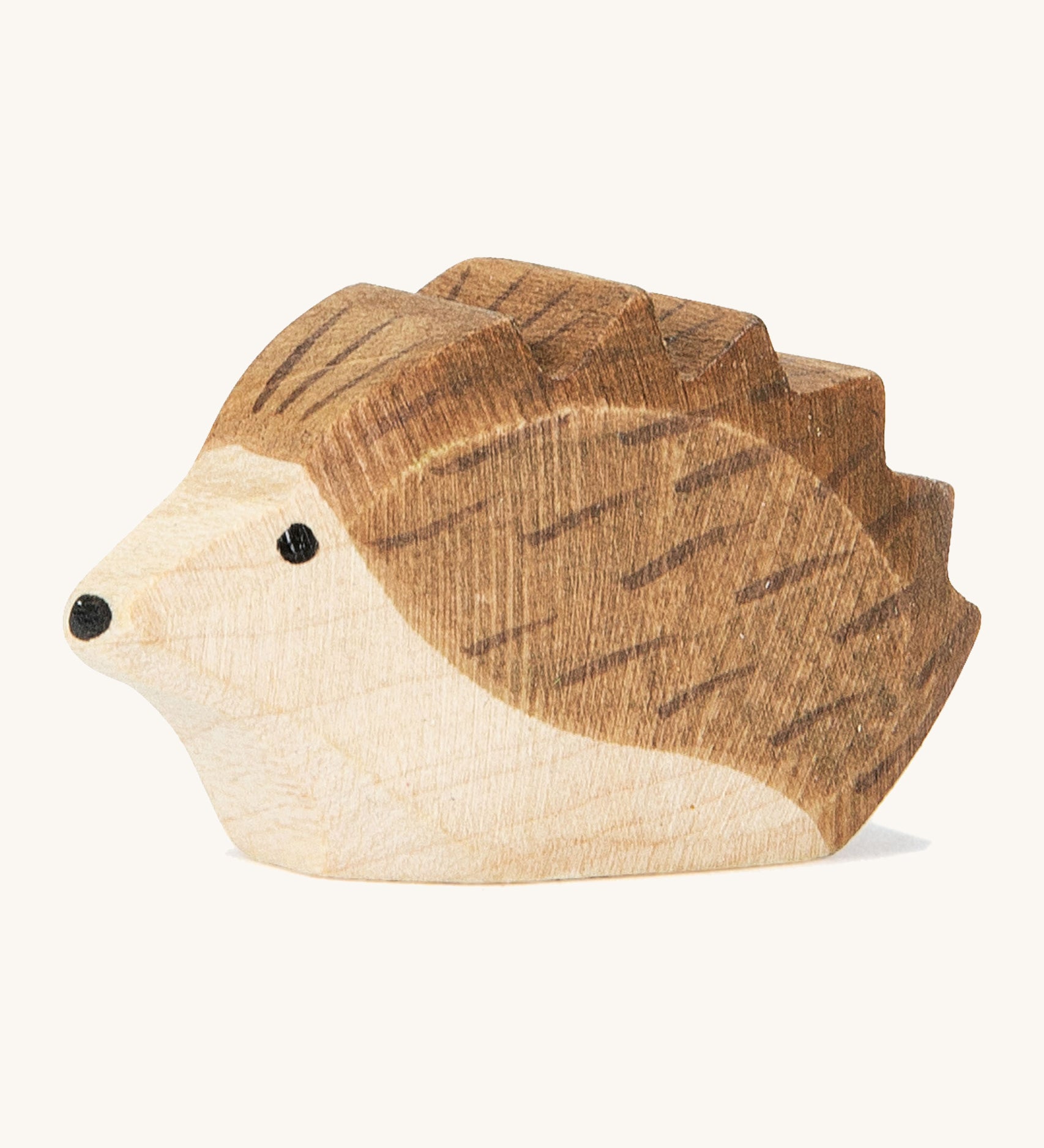 A small wooden Ostheimer hedgehog figure on a cream background.