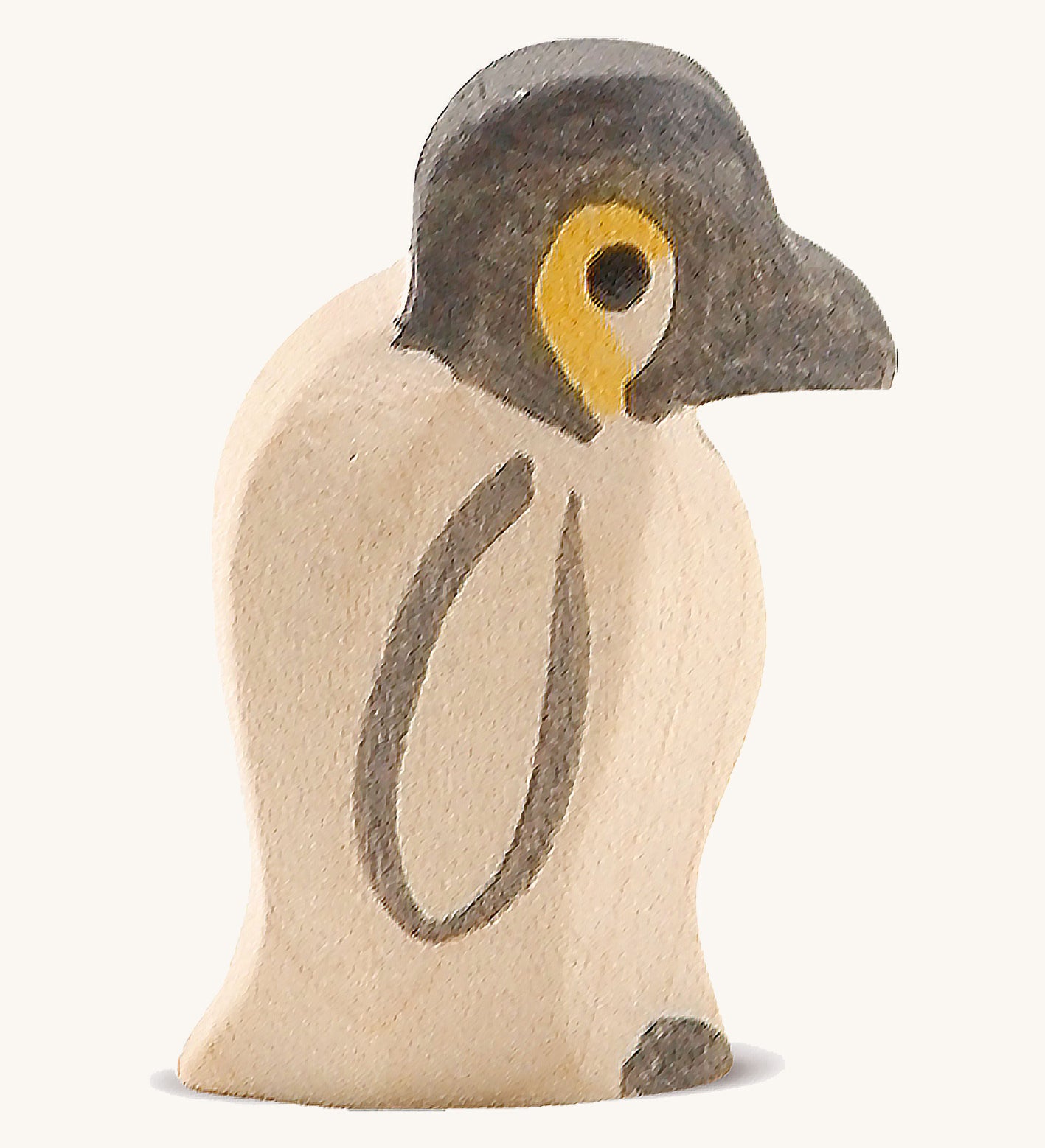 A small wooden Ostheimer penguin figure on a cream background.