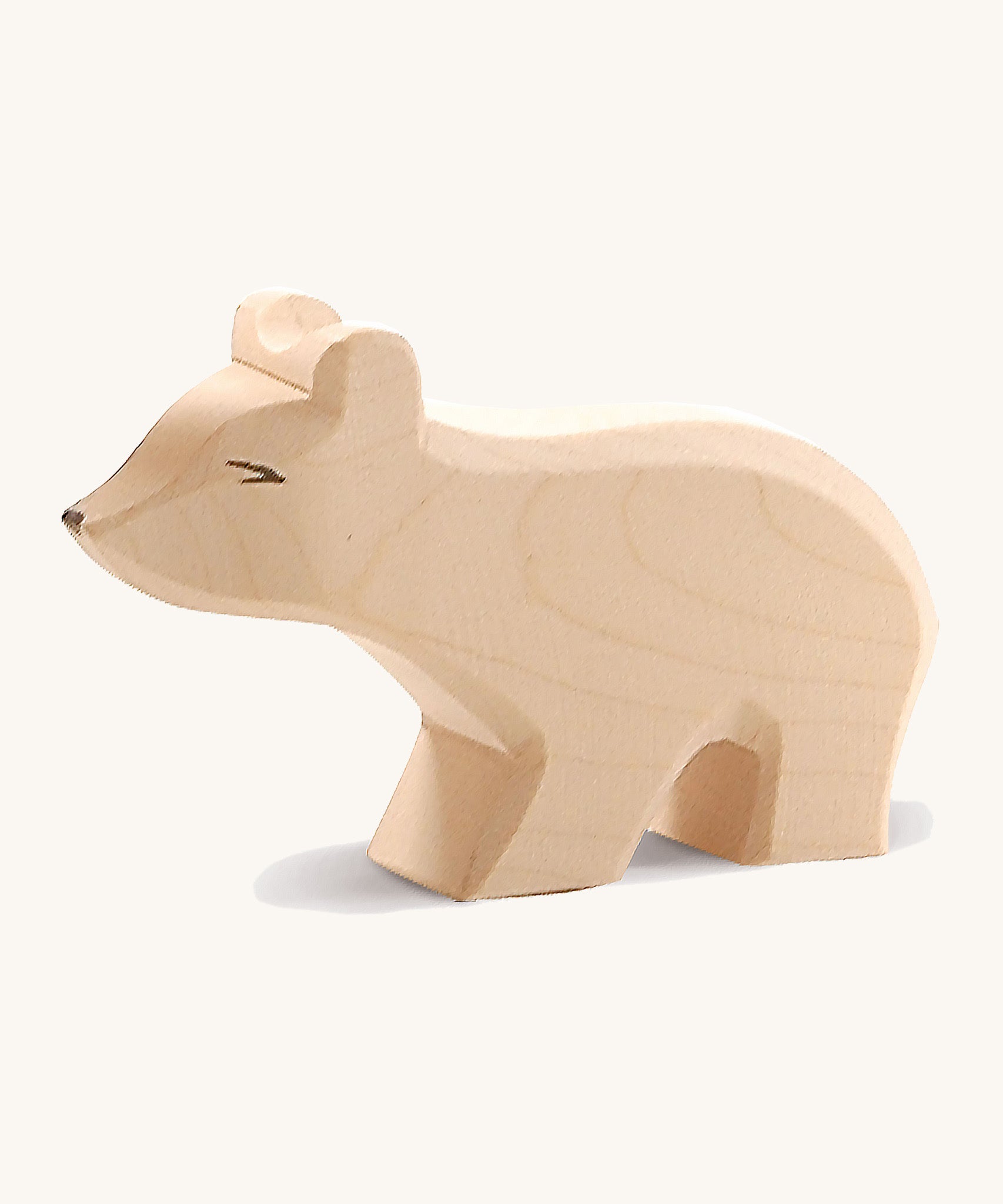 A small wooden Ostheimer polar bear figure with a long neck on a cream background.