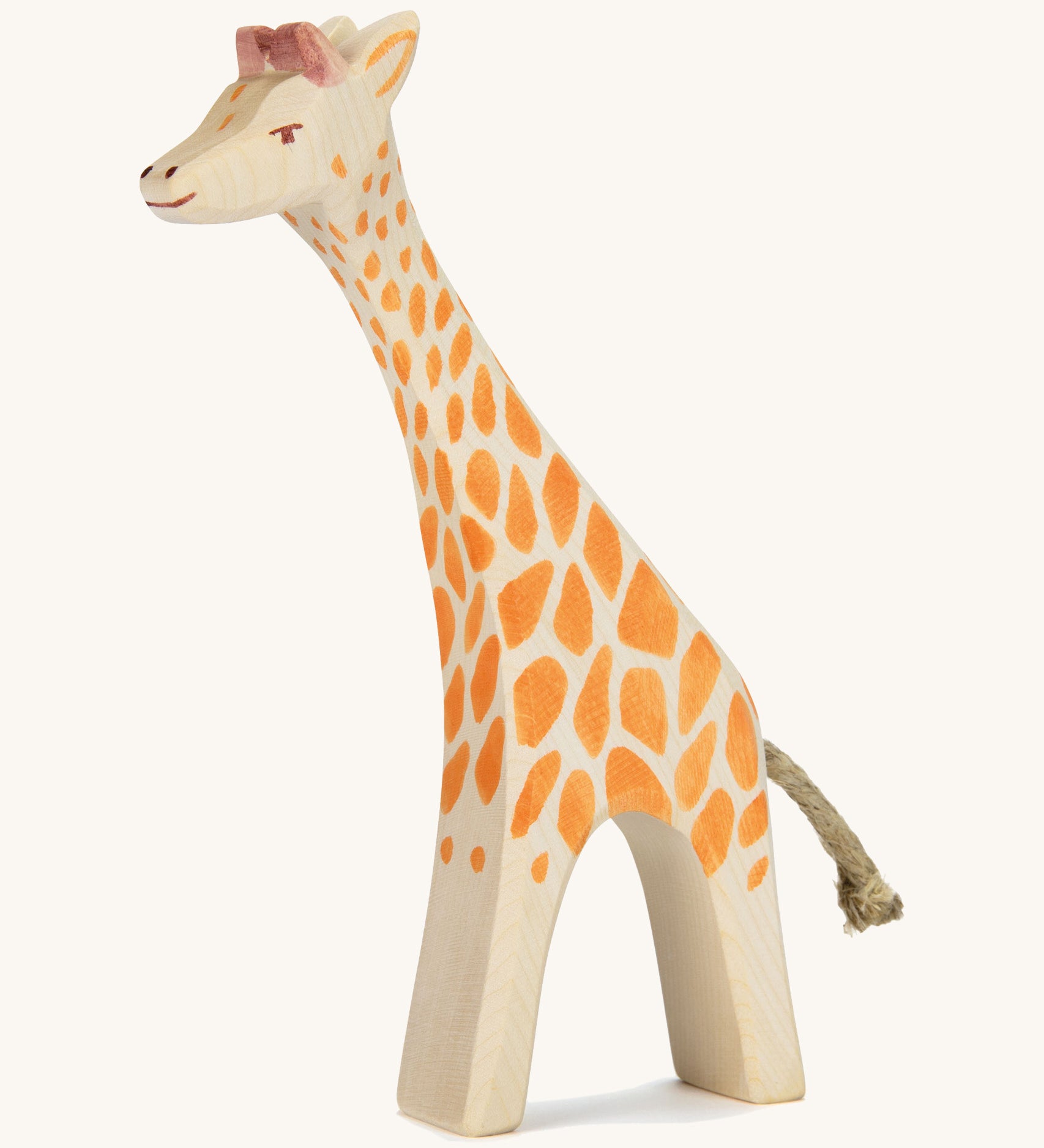 A wooden Ostheimer giraffe figure on a cream background.