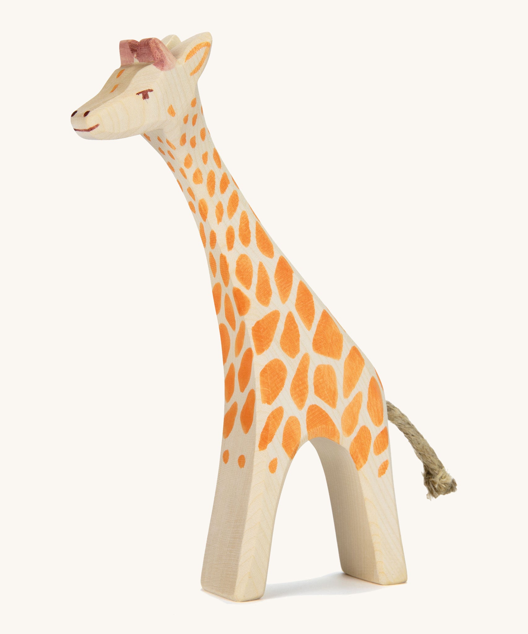 A wooden Ostheimer giraffe figure on a cream background.