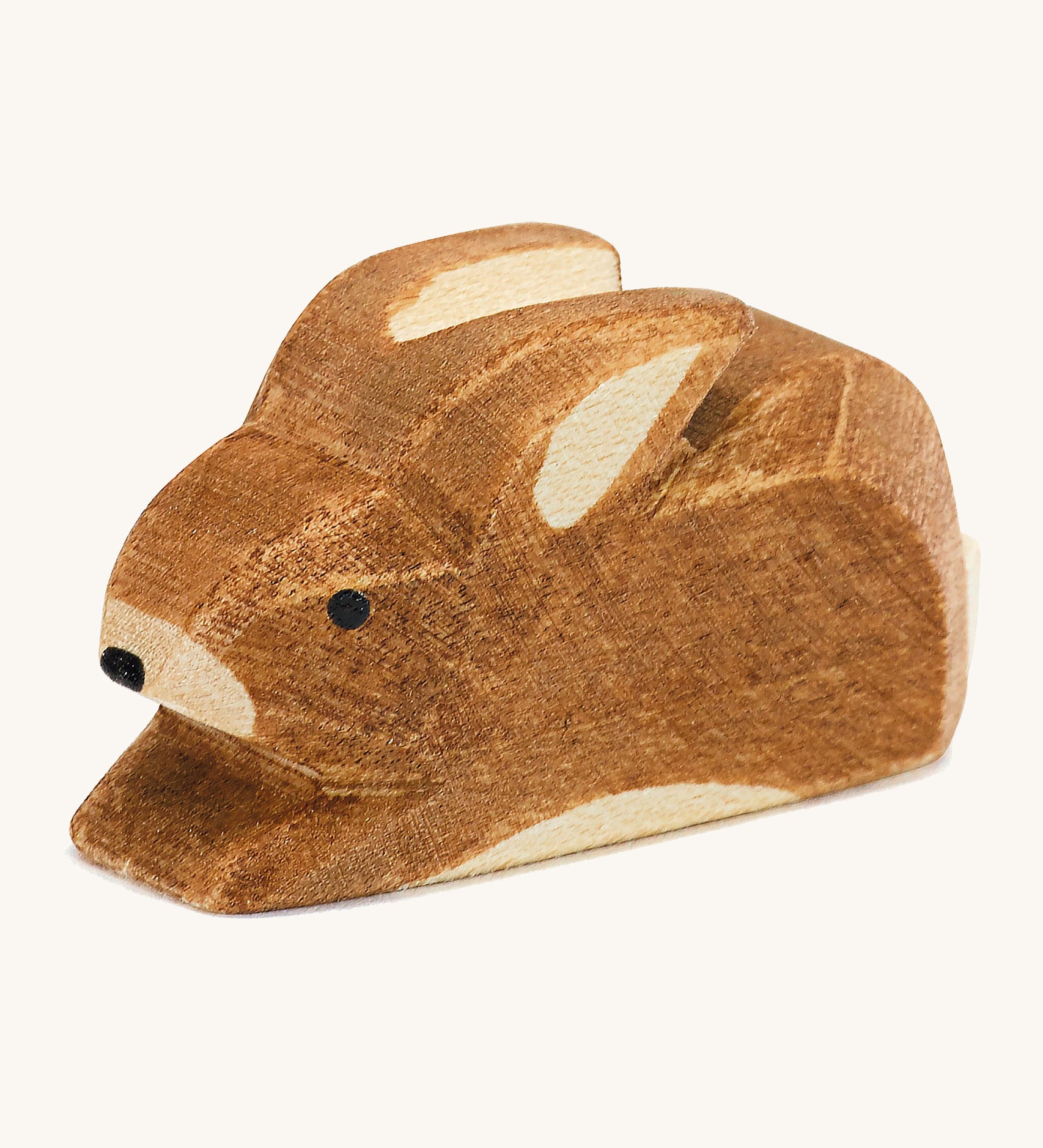 A small brown spotted Ostheimer rabbit figure on a cream background.