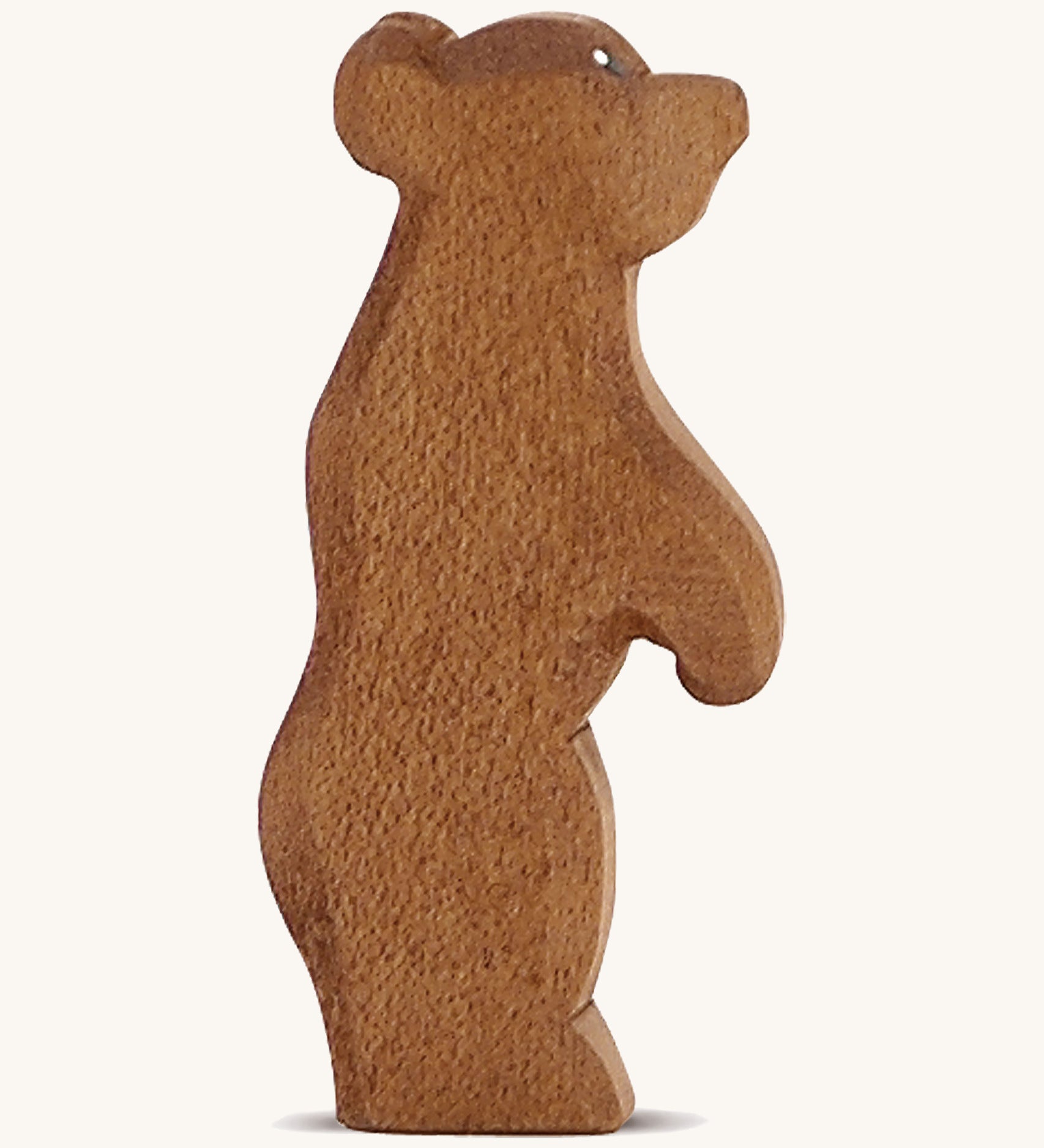 A Ostheimer wooden small brown standing bear figure on a cream background.