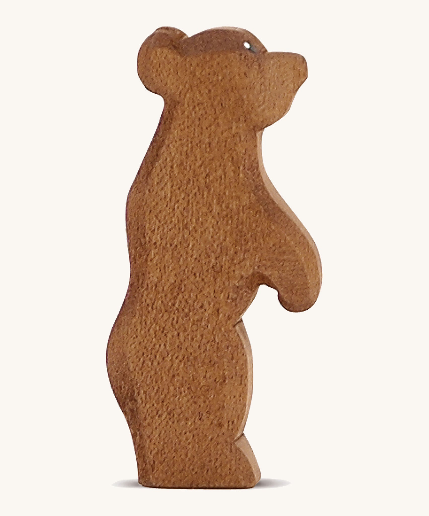 A Ostheimer wooden small brown standing bear figure on a cream background.