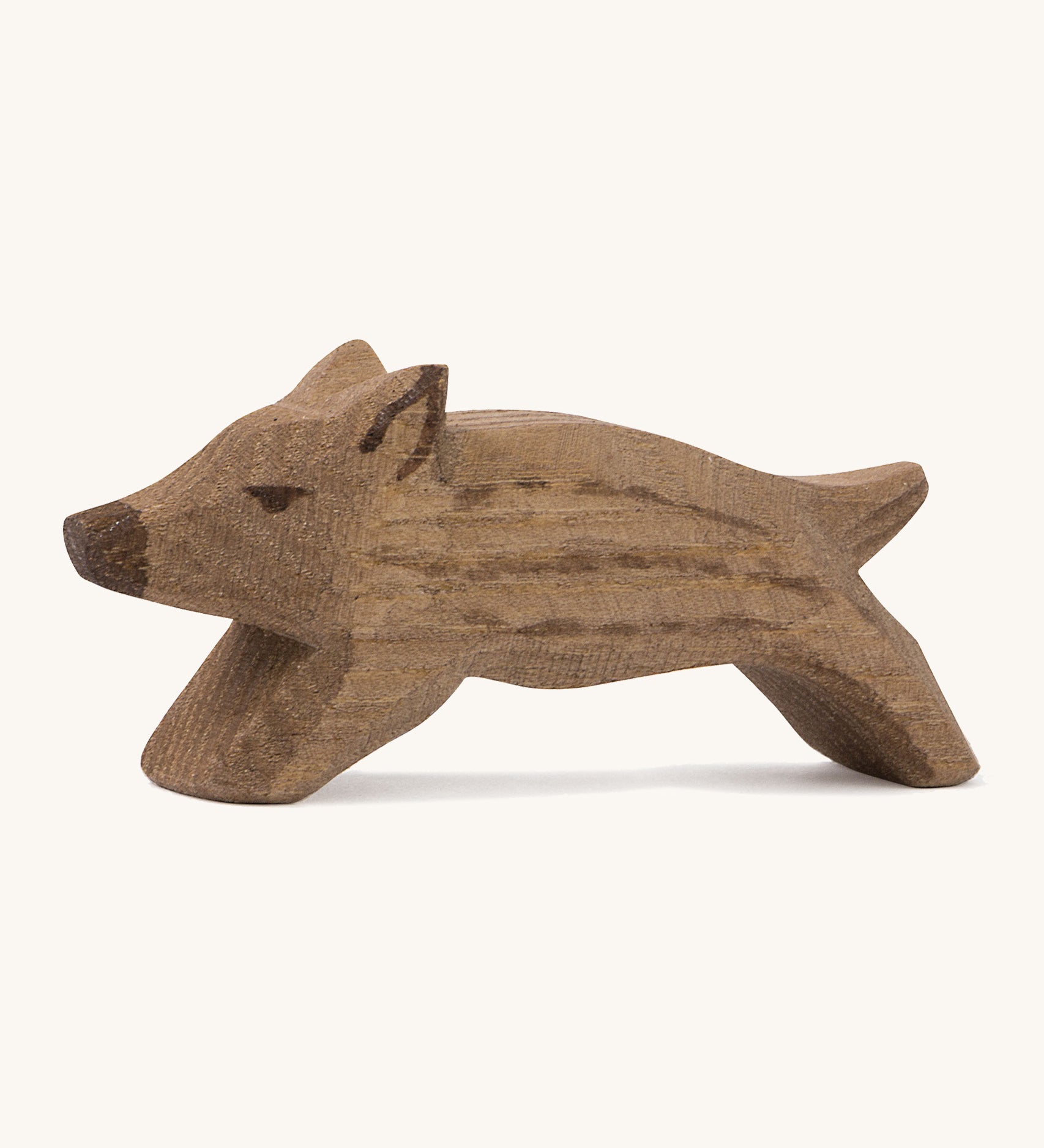 A small brown wild boar Ostheimer piglet figure on a cream background.