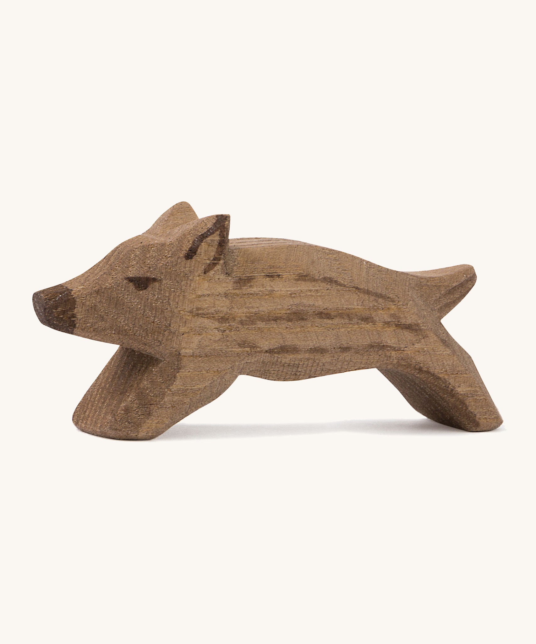 A small brown wild boar Ostheimer piglet figure on a cream background.