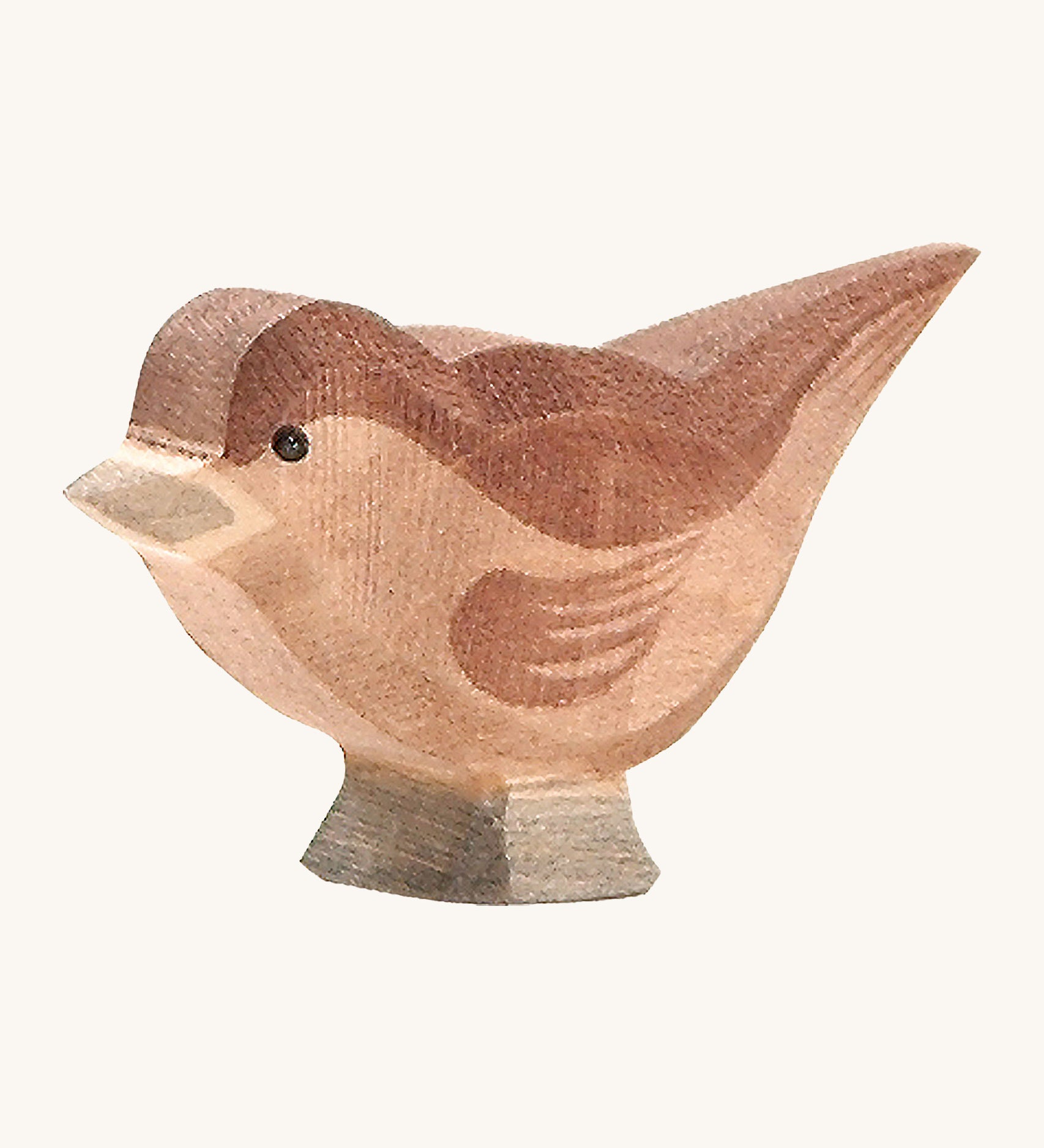 A wooden Ostheimer sparrow bird figure on a cream background.