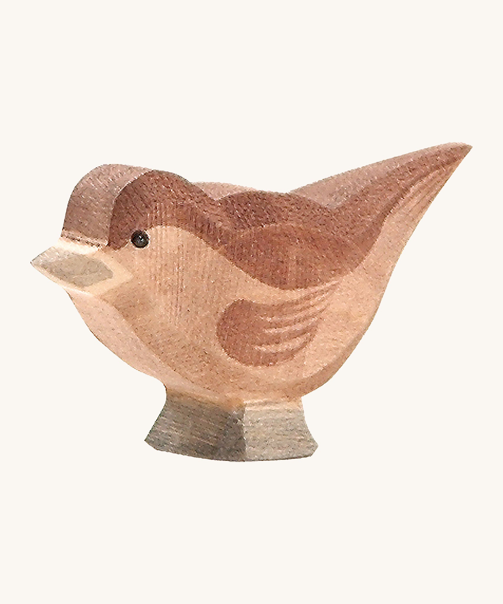 A wooden Ostheimer sparrow bird figure on a cream background.