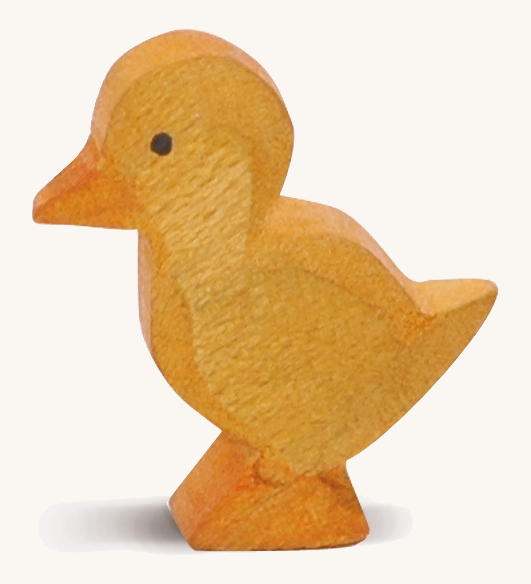 A yellow wooden Ostheimer duckling figure on a cream background.