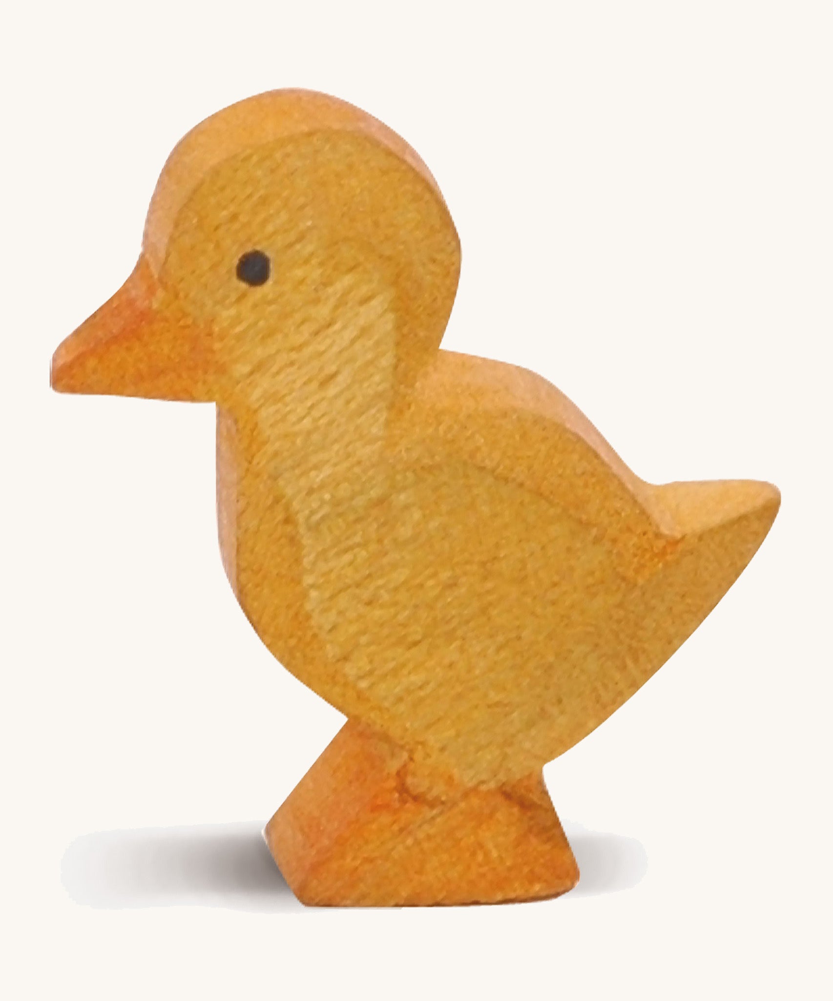 A yellow wooden Ostheimer duckling figure on a cream background.