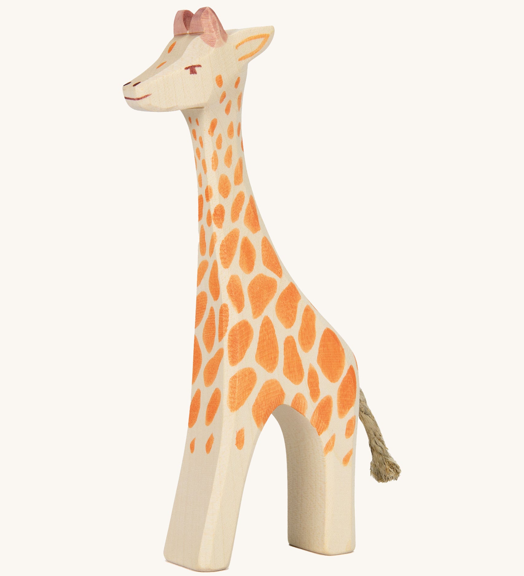 A wooden standing Ostheimer giraffe figure on a cream background.