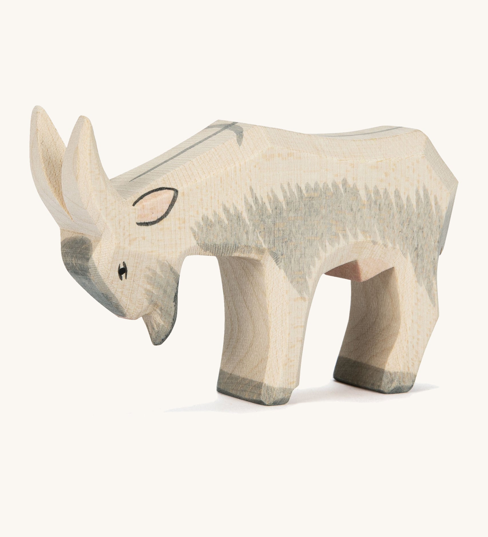 A grey and white wooden Ostheimer goat figure on a cream background.