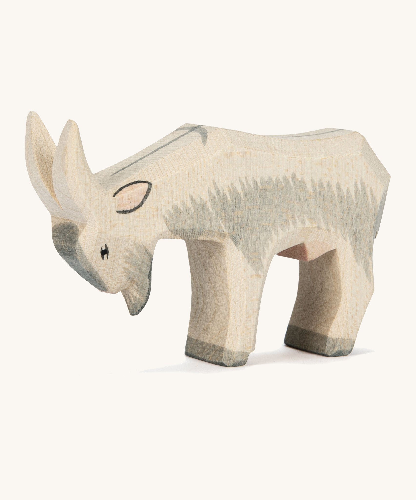 A grey and white wooden Ostheimer goat figure on a cream background.