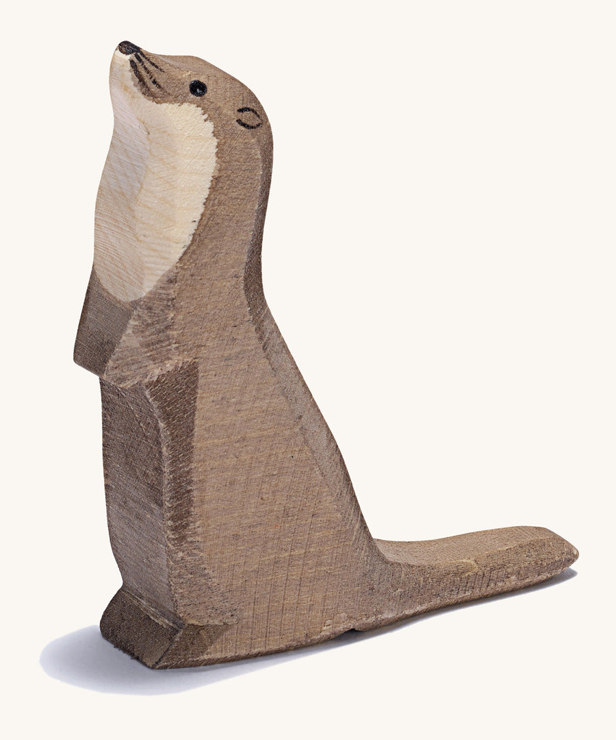 A wooden standing Ostheimer sea otter figure on a cream background