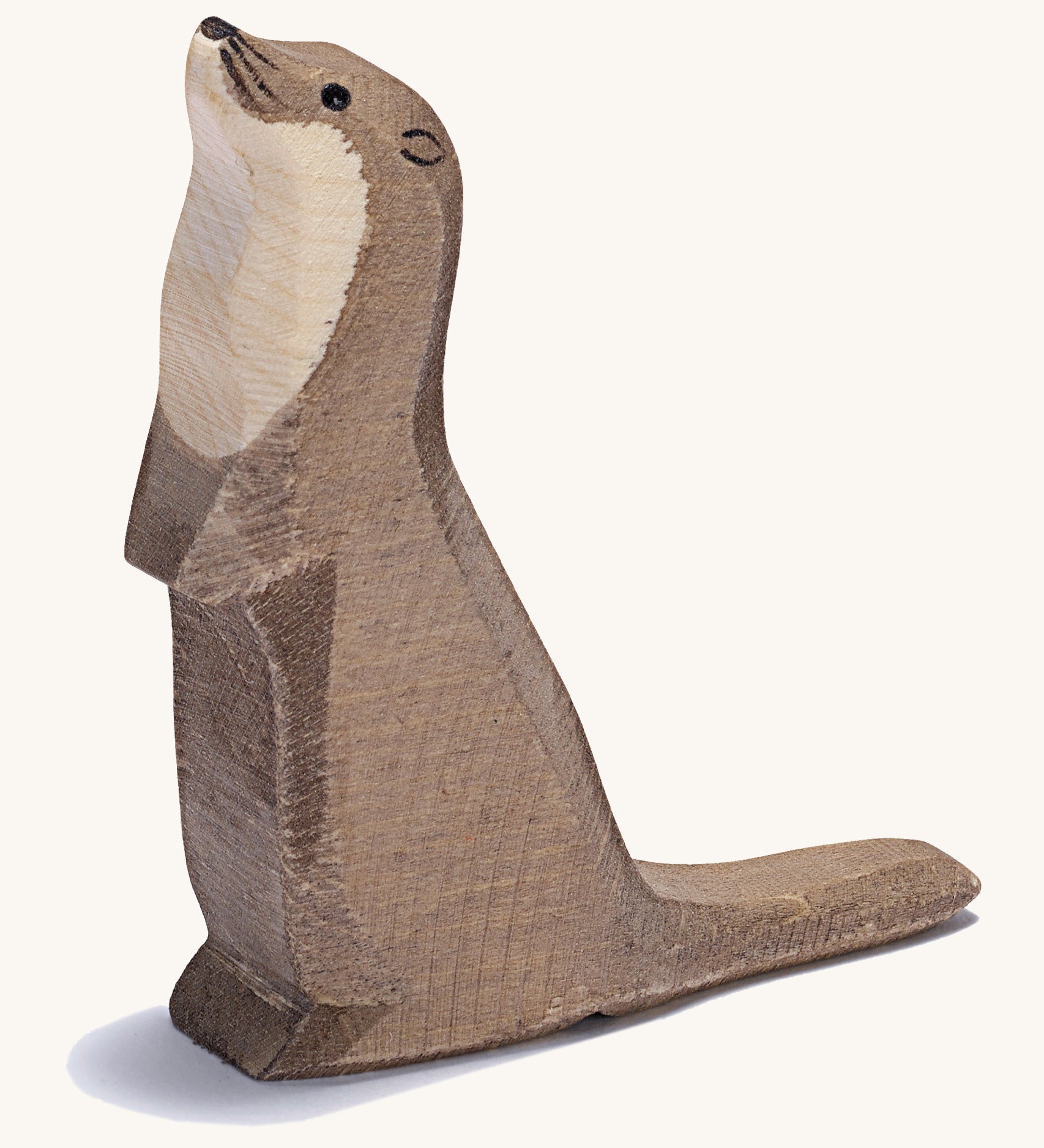 A wooden standing Ostheimer sea otter figure on a cream background