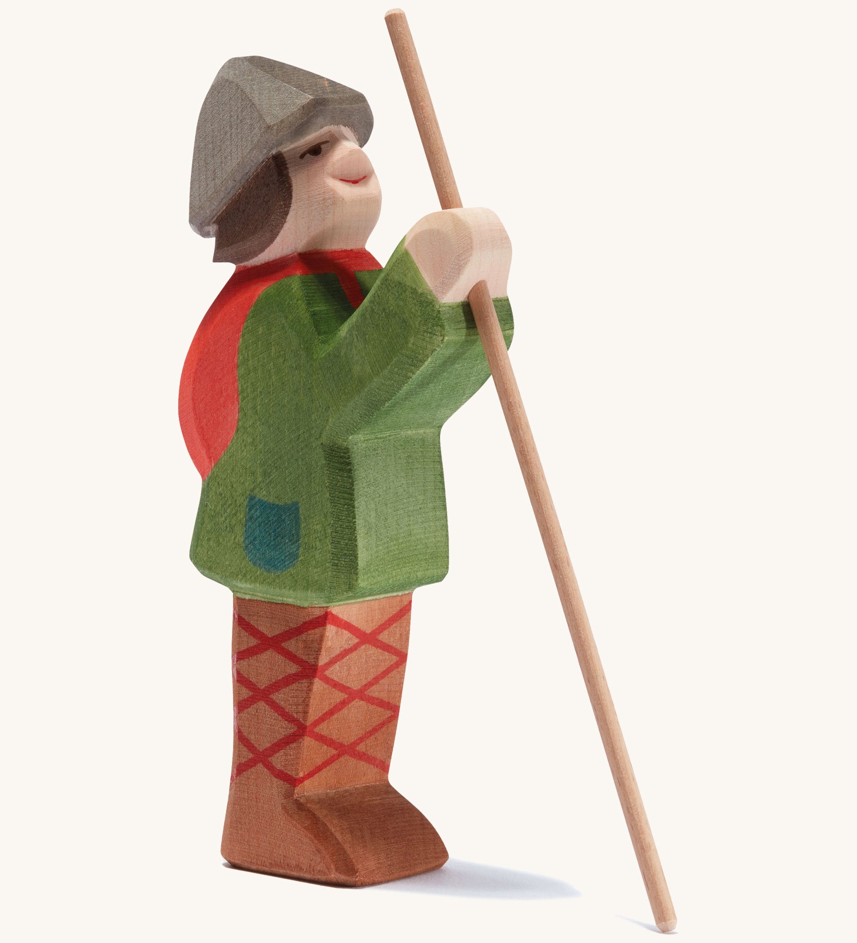 A wooden standing Ostheimer shepherd figure holding a wooden staff on a cream background.