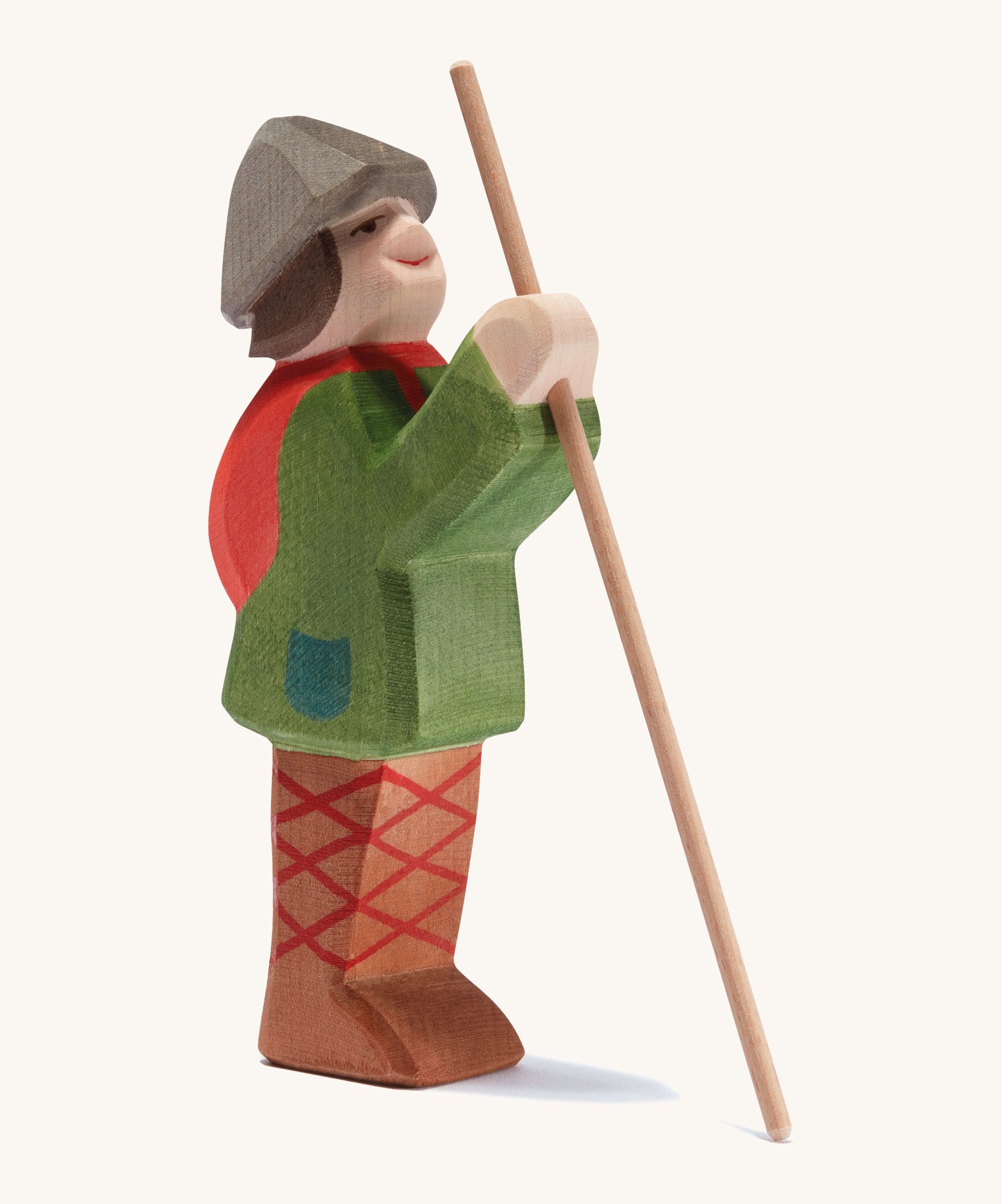 A wooden standing Ostheimer shepherd figure holding a wooden staff on a cream background.