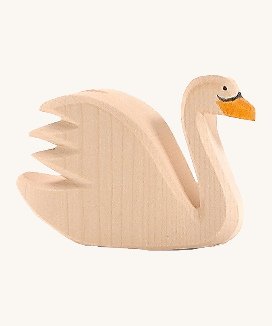 A wooden Ostheimer swan figure on a cream background.