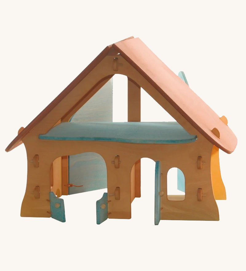 Ostheimer wooden farm house toy with light red roof and light blue doors on a plain background. 