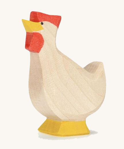 A wooden Ostheimer hen toy with it's head facing up on a plain background. 