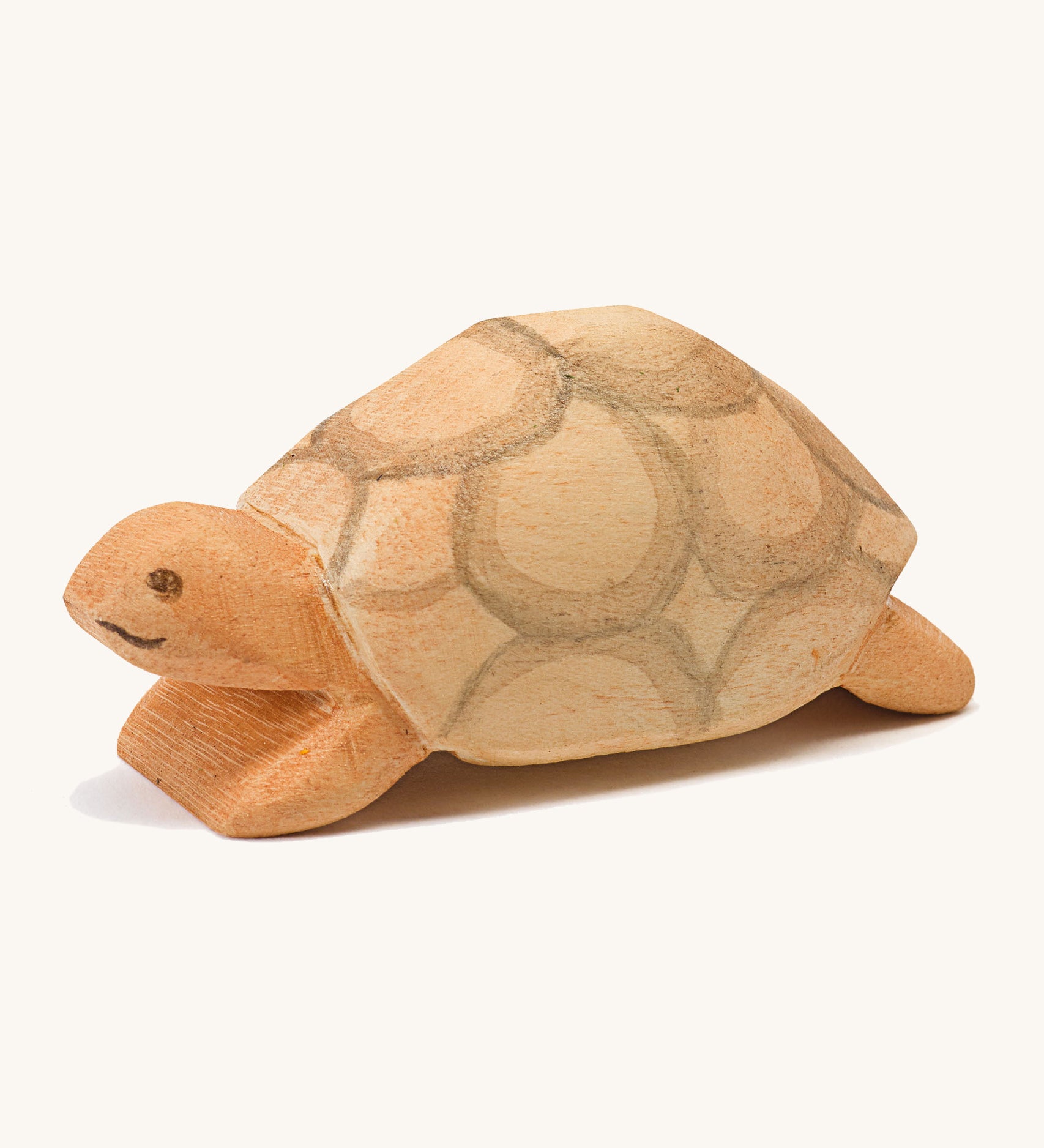 A wooden Ostheimer turtle on a cream background.