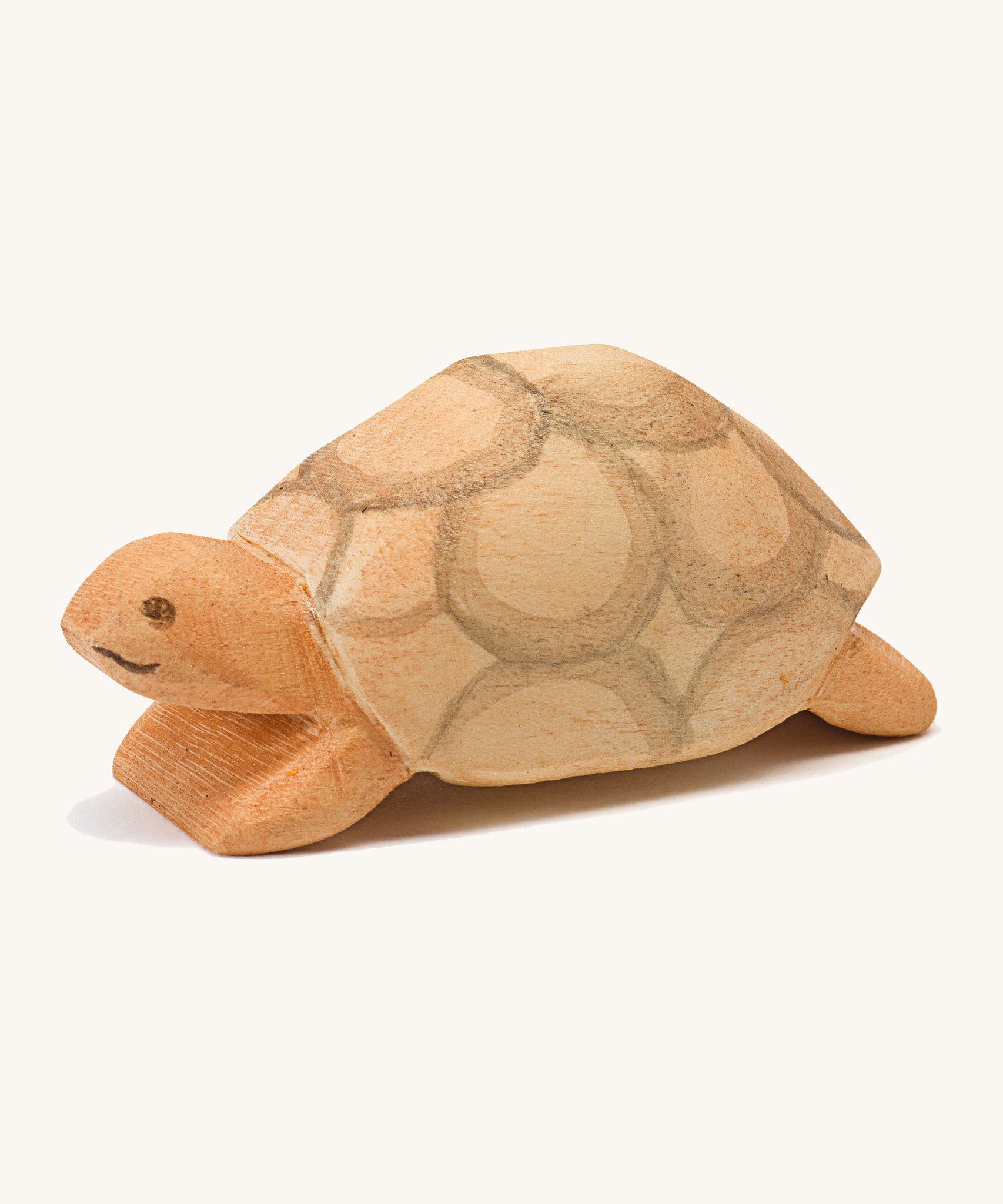 A wooden Ostheimer turtle on a cream background.