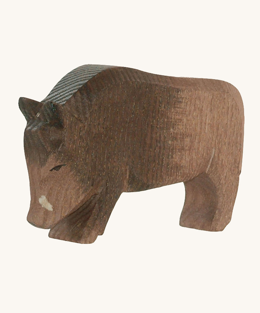 A wooden Ostheimer wild boar figure on a cream background.