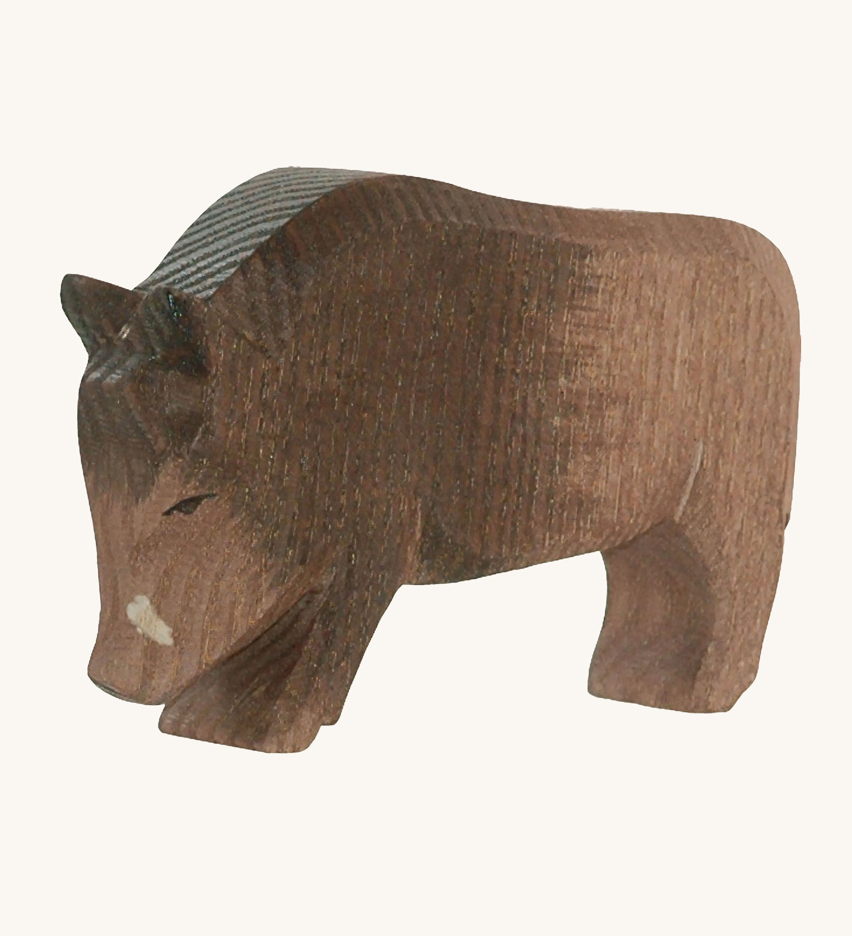 A wooden Ostheimer wild boar figure on a cream background.