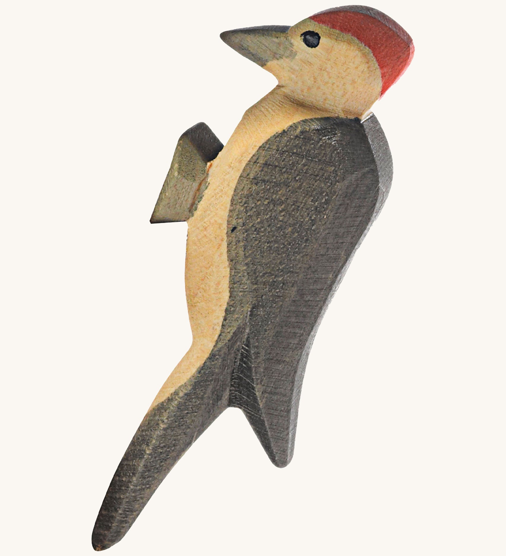 A wooden Ostheimer woodpecker figure on a cream background.