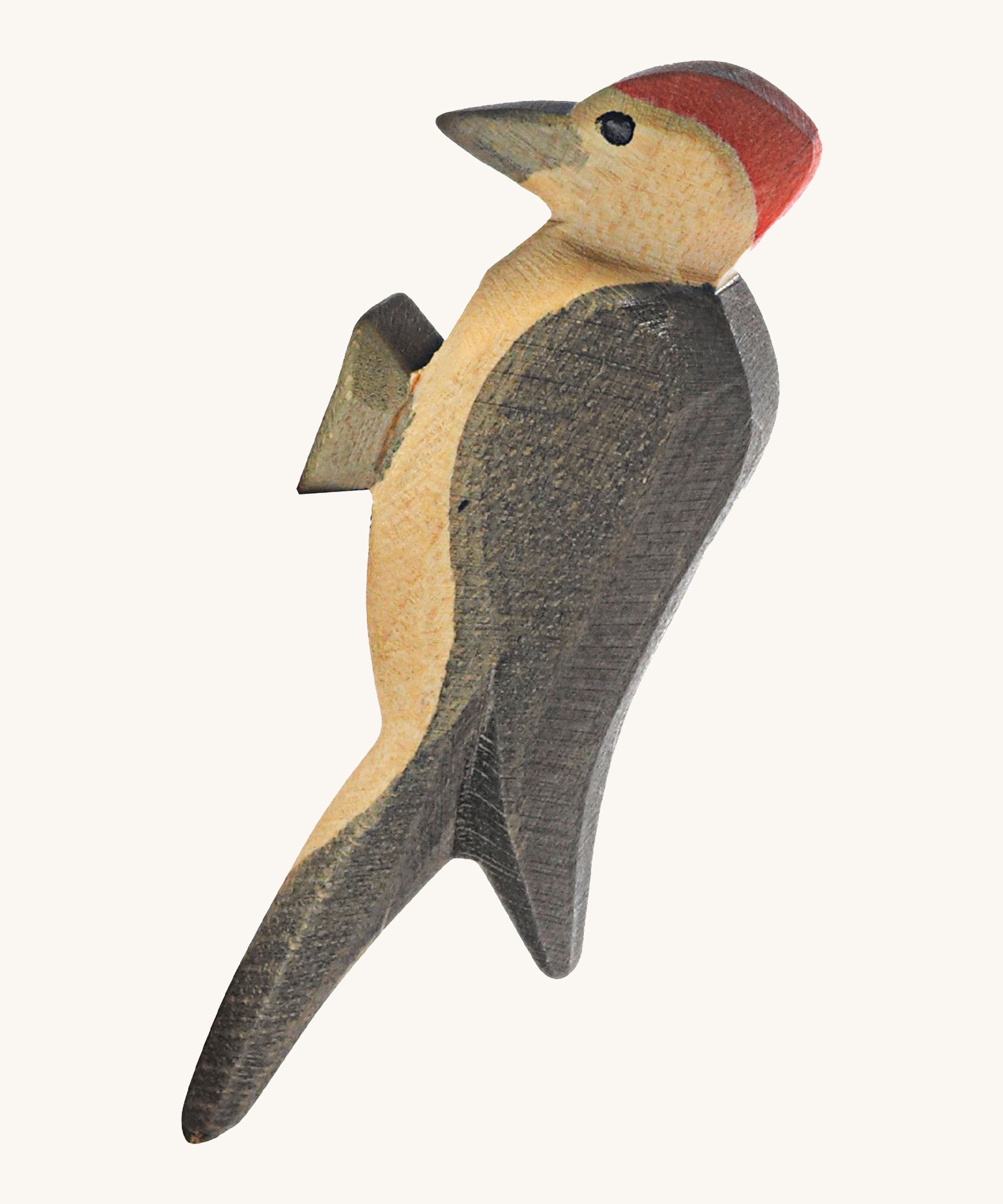 A wooden Ostheimer woodpecker figure on a cream background.