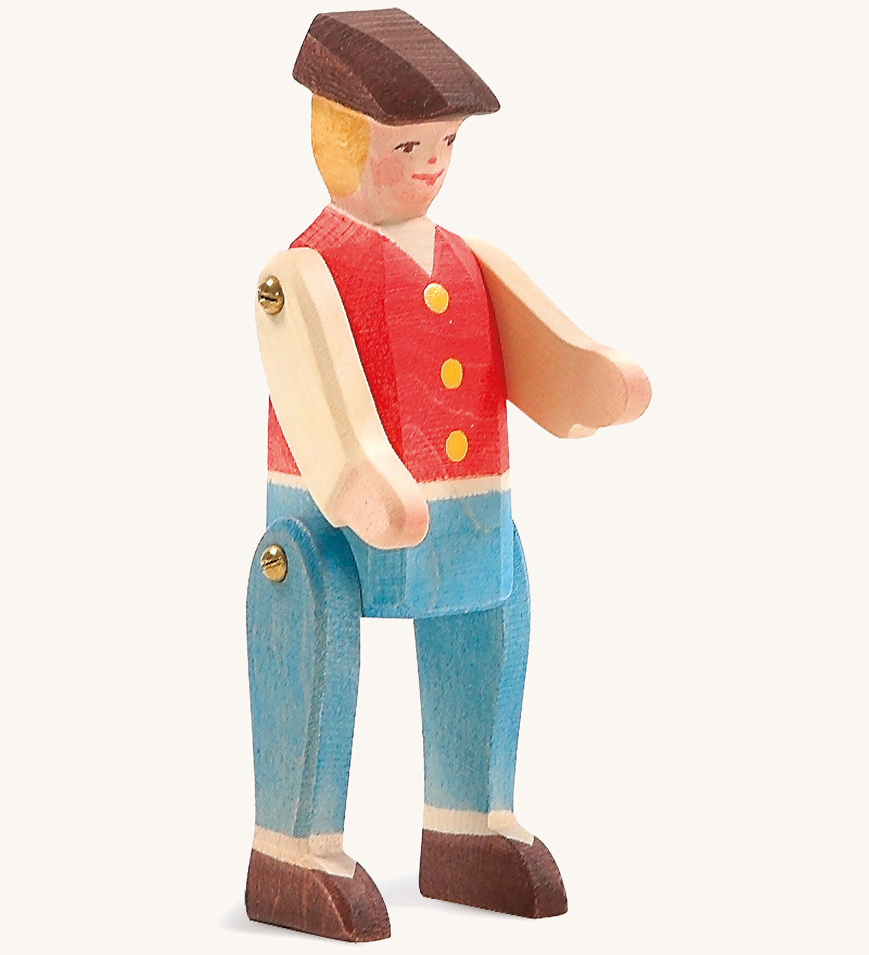 A wooden Ostheimer rider figure wearing a red waistcoat, blue trousers and a brown hat on a cream background.