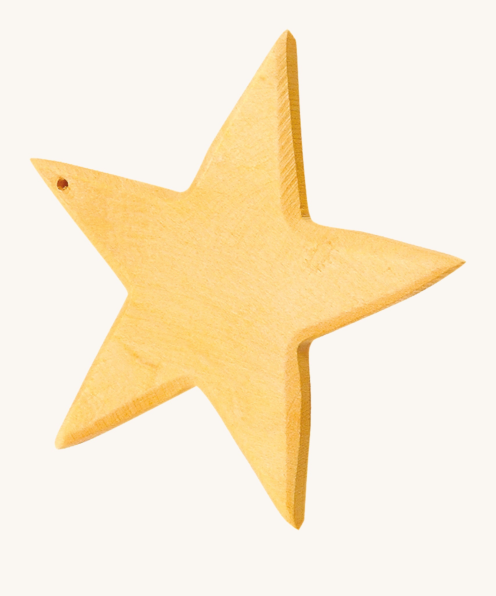 A yellow wooden star figure on a cream background