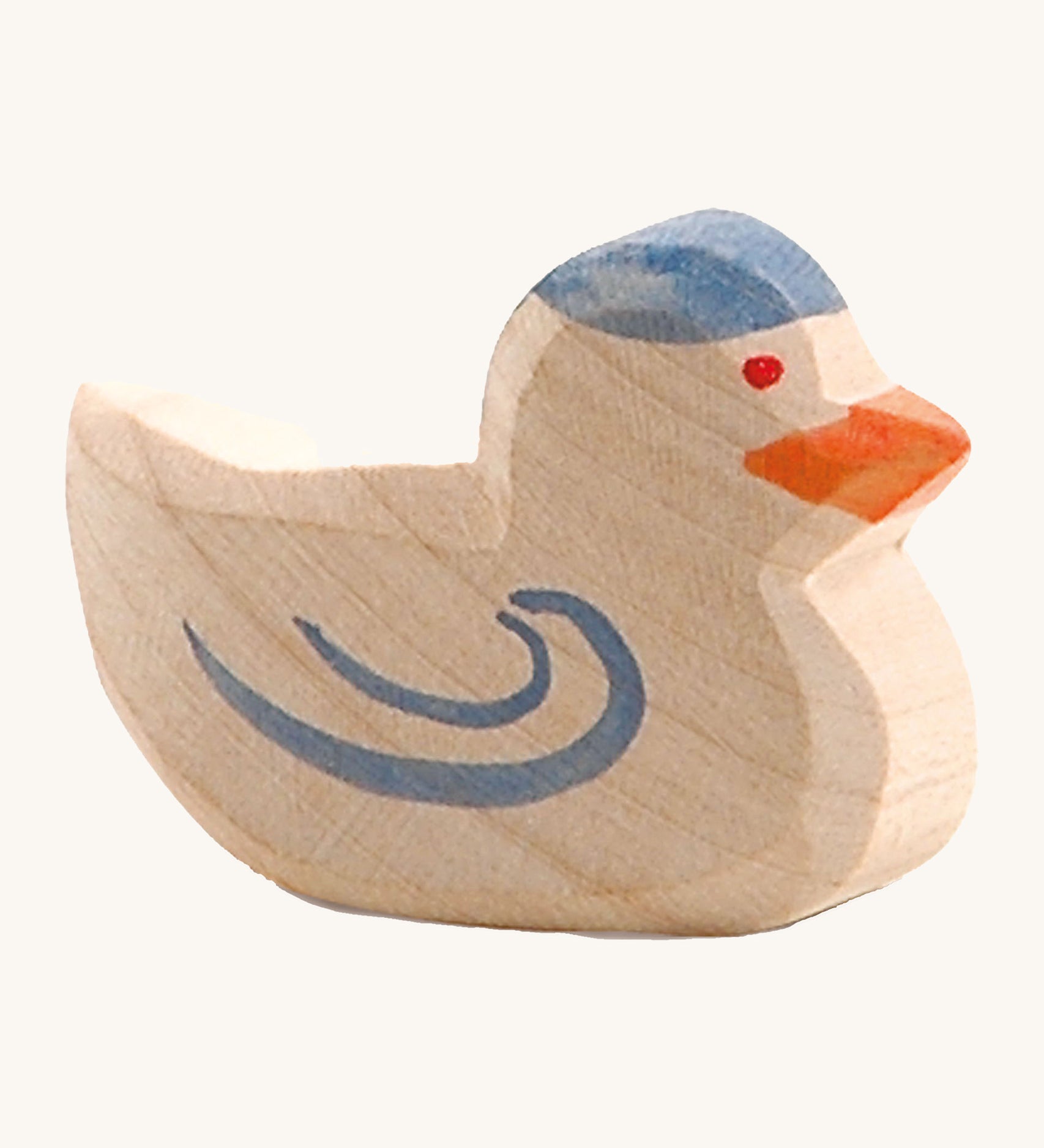 A wooden Ostheimer pigeon figure on a cream background.