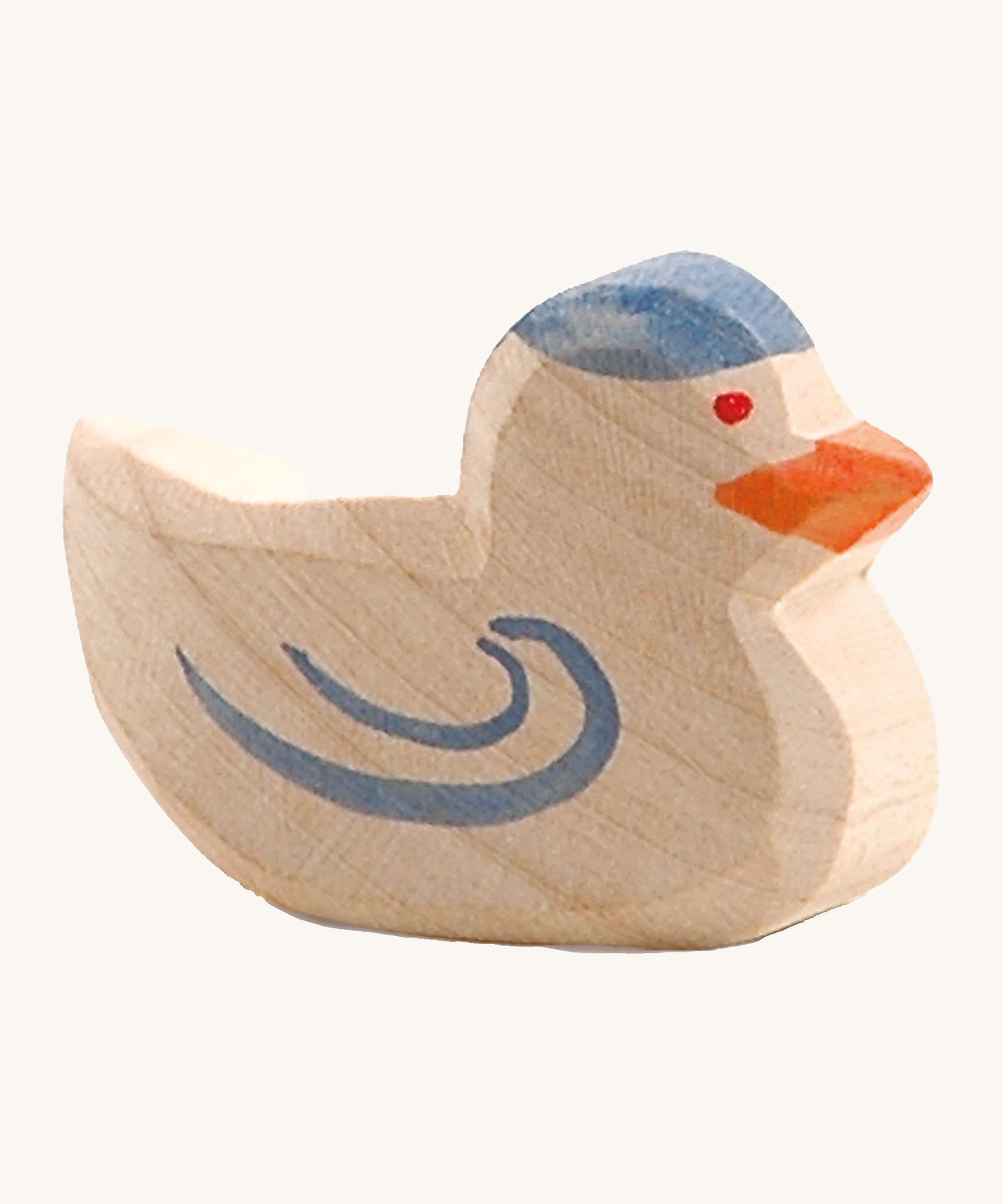 A wooden Ostheimer pigeon figure on a cream background.