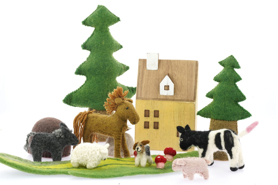 sheep and dog toys on a Papoose play mat in front of a wooden house